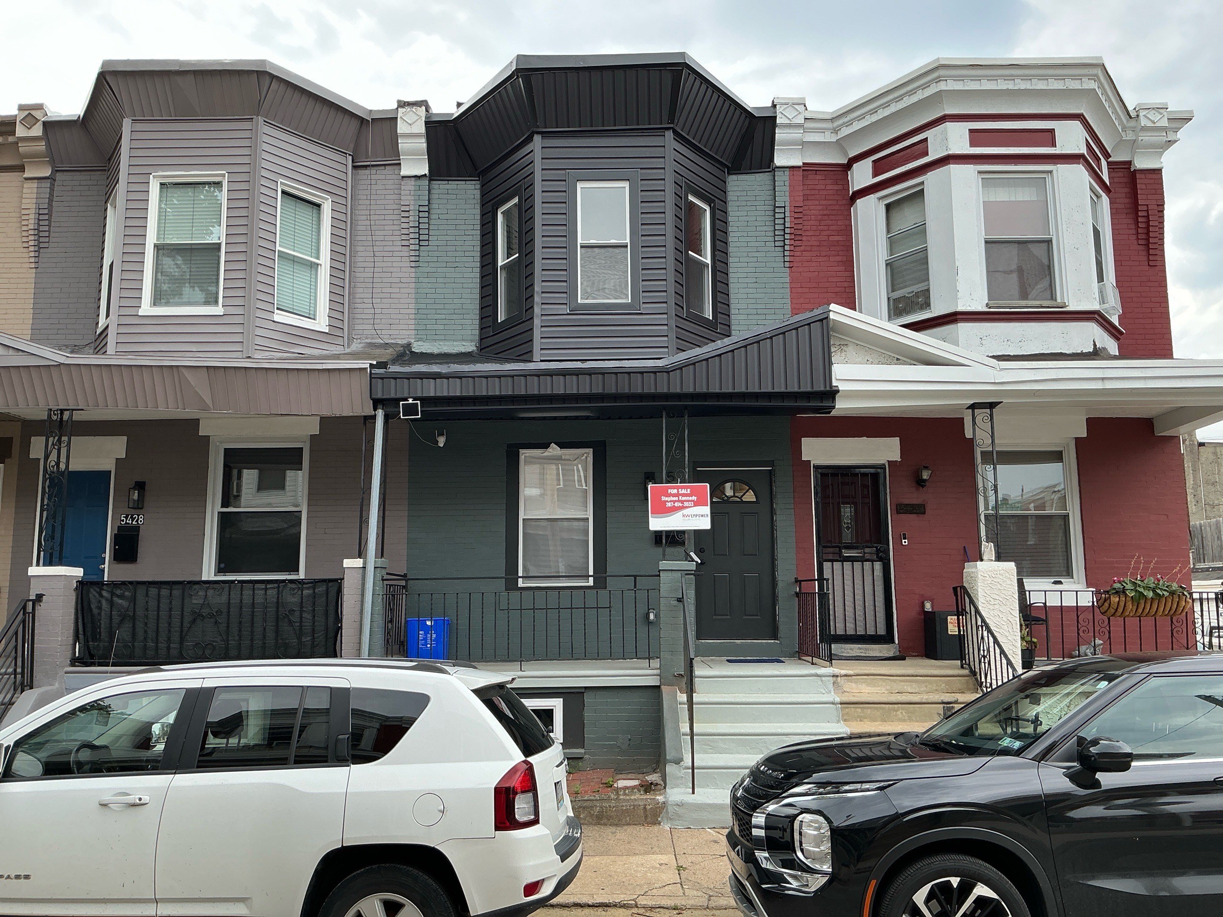 Freshly painted charcoal-brick rowhouse facade on a West Philadelphia flip
