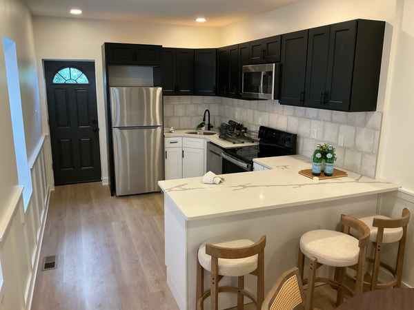 Staged flip kitchen with white shaker cabinets, quartz counters, and stainless steel appliances