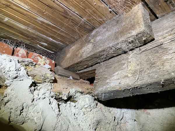 Over-notched floor joist resting on a deteriorating masonry pocket