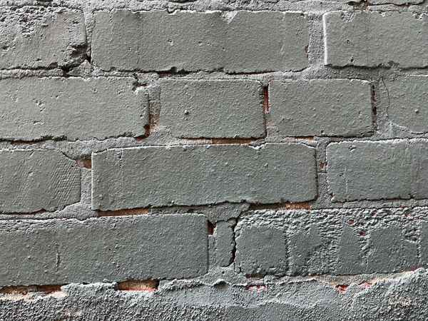 Fresh paint over deteriorated, crumbling brick mortar joints