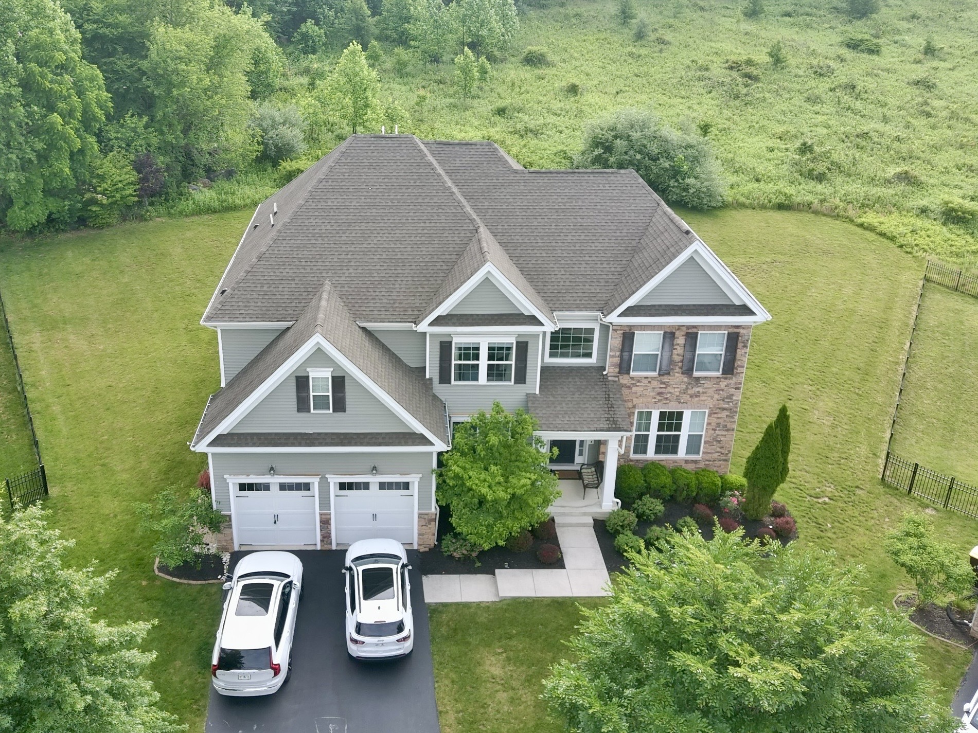 Aerial home inspection by Cory Shalaway — gray siding and stone colonial with two-car garage in Chester Springs, Pennsylvania