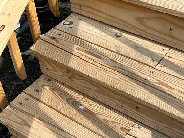 Defects in brand-new exterior wood stairs on a flipped rowhouse