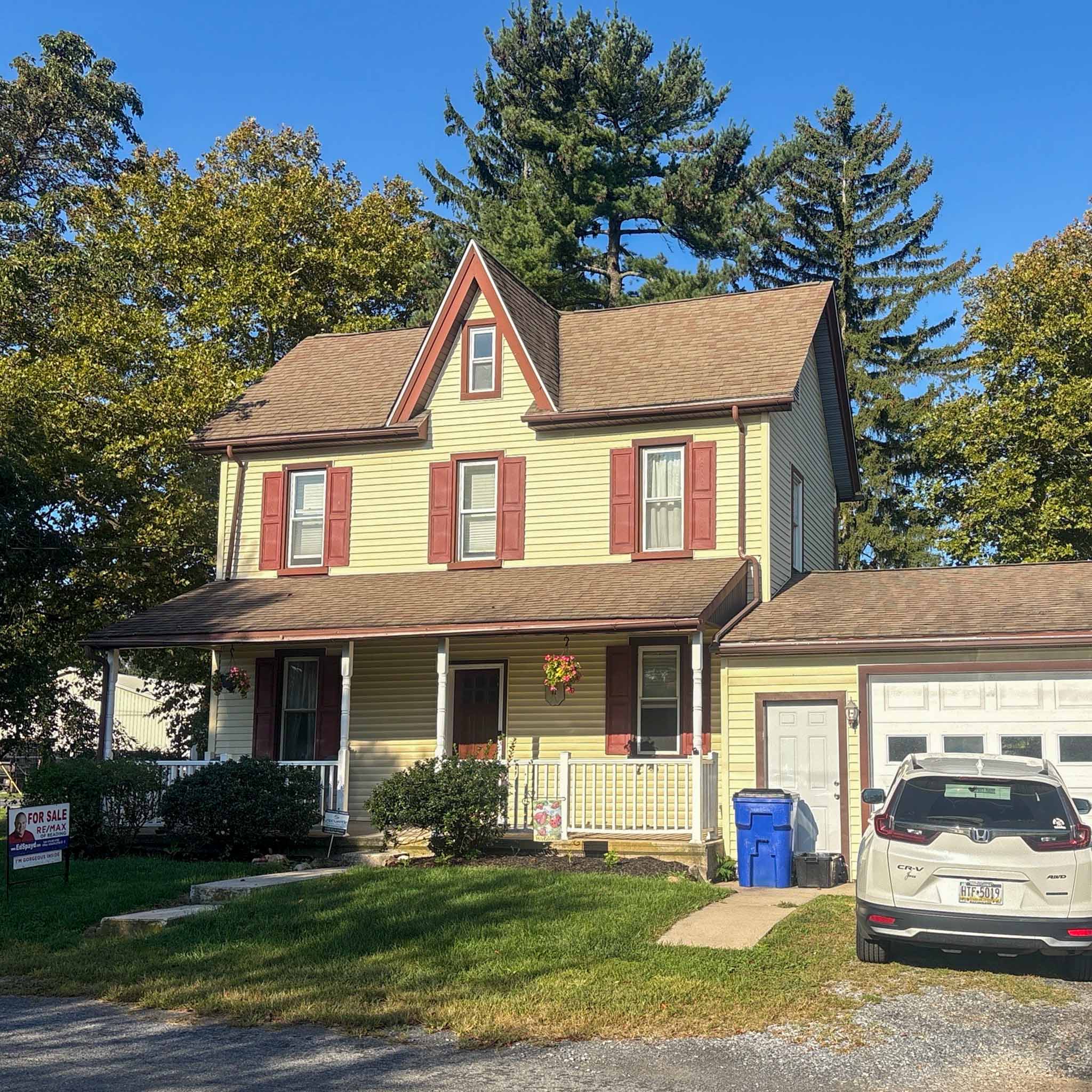 Yellow folk Victorian farmhouse with a steep front gable and covered porch in Fleetwood, Berks County inspected by ValueGuard home inspectors