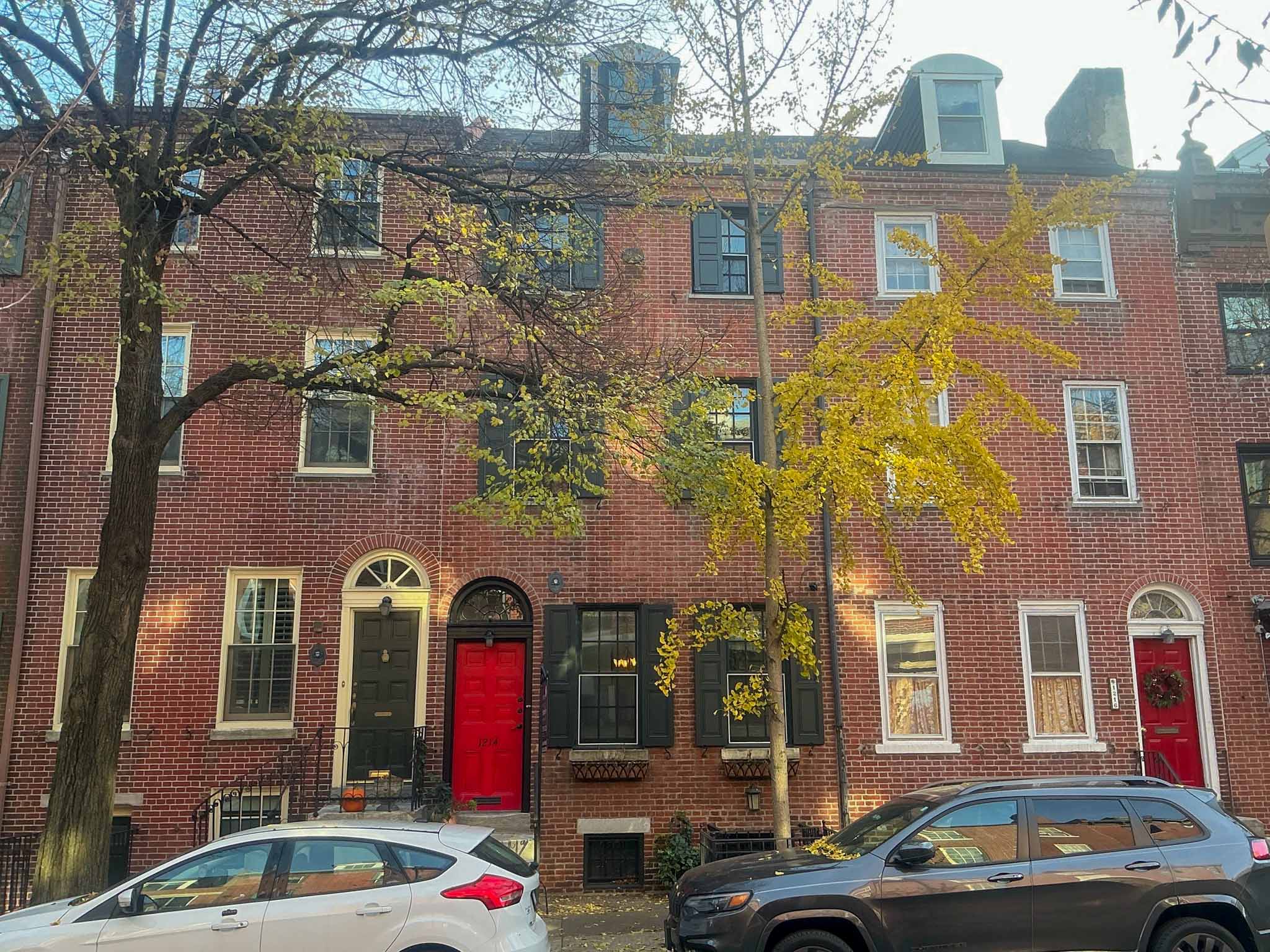 ValueGuard home inspection — renovated three-story brick rowhome with dark louvered shutters and tree-shaded courtyard entry in Washington Square West Philadelphia
