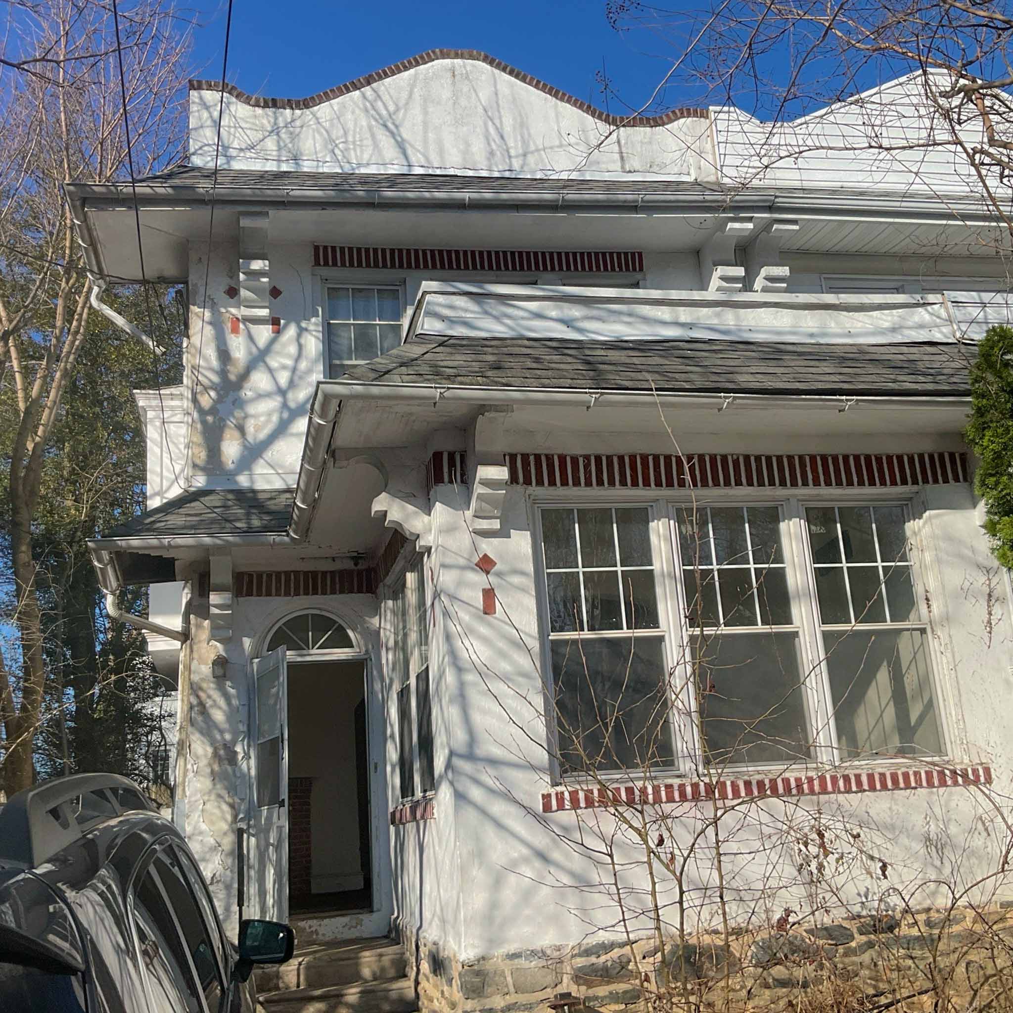 Ardmore Home Inspection — Early-1900s Foursquare Older painted-masonry Foursquare with a low parapet roofline and tile-trim awnings, mid-renovation, in Ardmore, Montgomery County PA, inspected by ValueGuard home inspectors