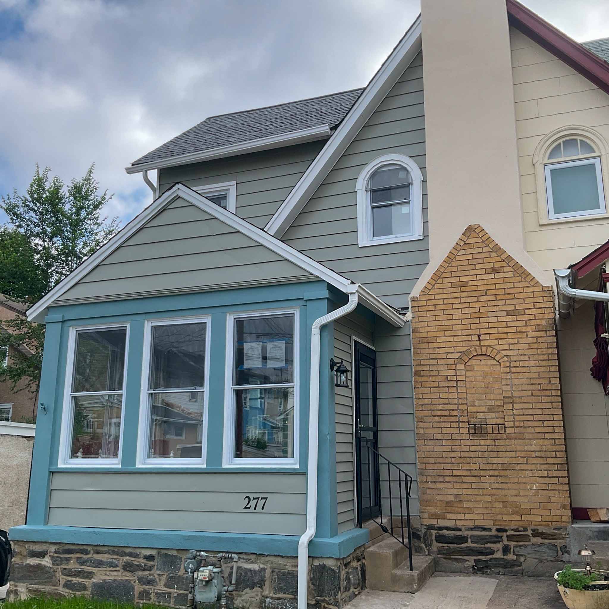 Ardmore Home Inspection — Updated Twin Updated gray-sided twin home (unit 277) with a blue-trim front sunroom and stone foundation in Ardmore, Montgomery County PA, inspected by a ValueGuard home inspector