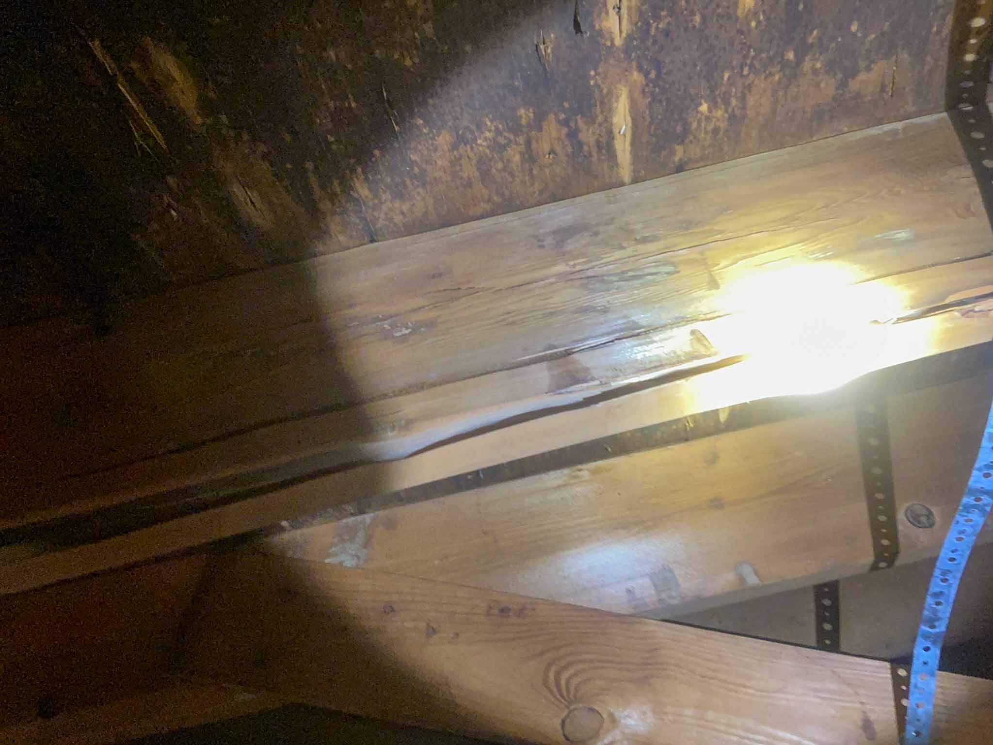 Cracked roof framing member in the attic, with daylight visible through the split, found during an Aston PA home inspection