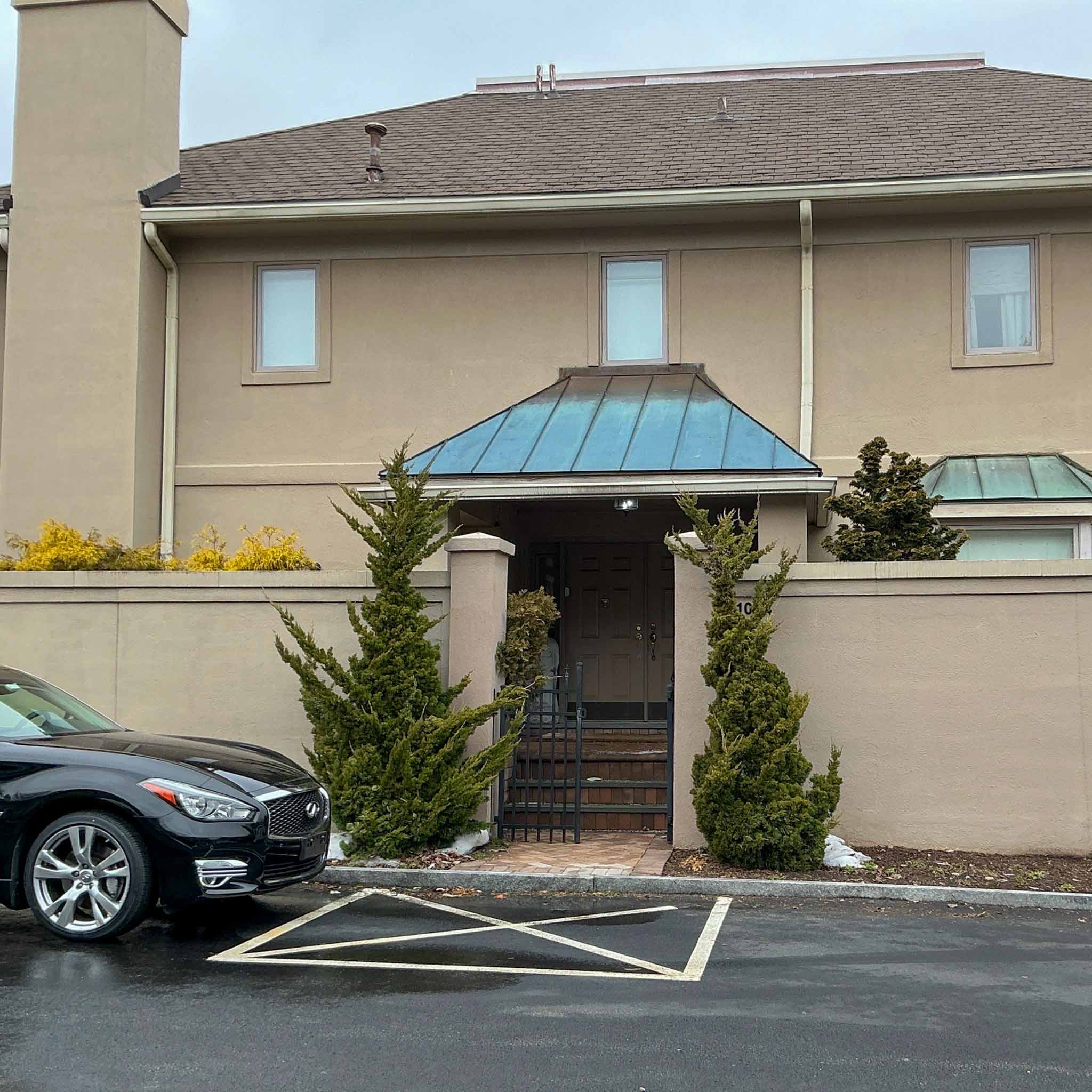 Stucco condominium townhouse unit with a patinated copper entry canopy in a Bala Cynwyd community inspected by ValueGuard
