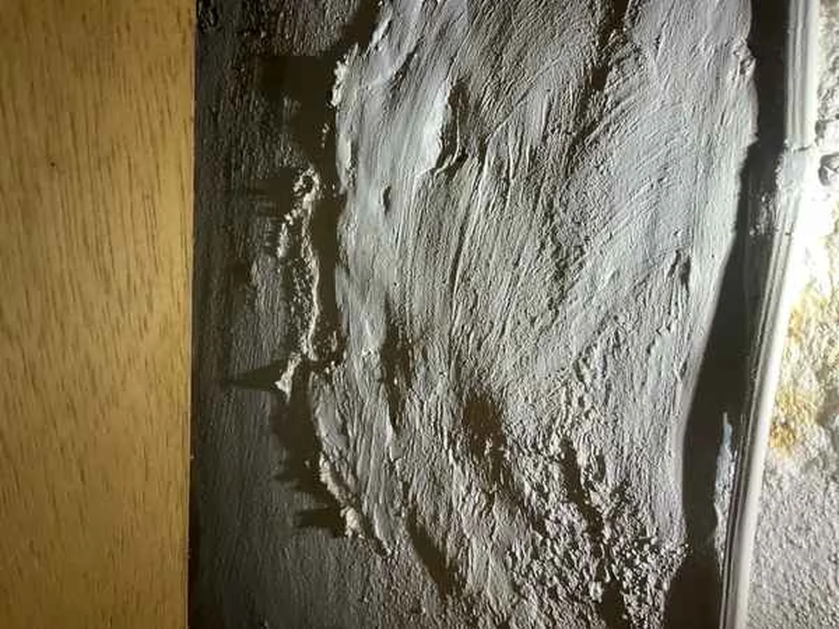 Efflorescence and staining on a basement foundation wall documented in a home inspection report