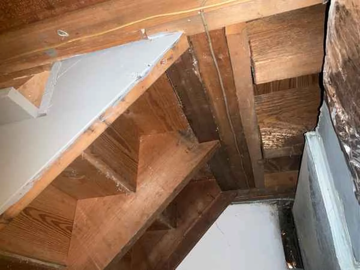 Basement stairs found poorly attached during a home inspection, photographed from below