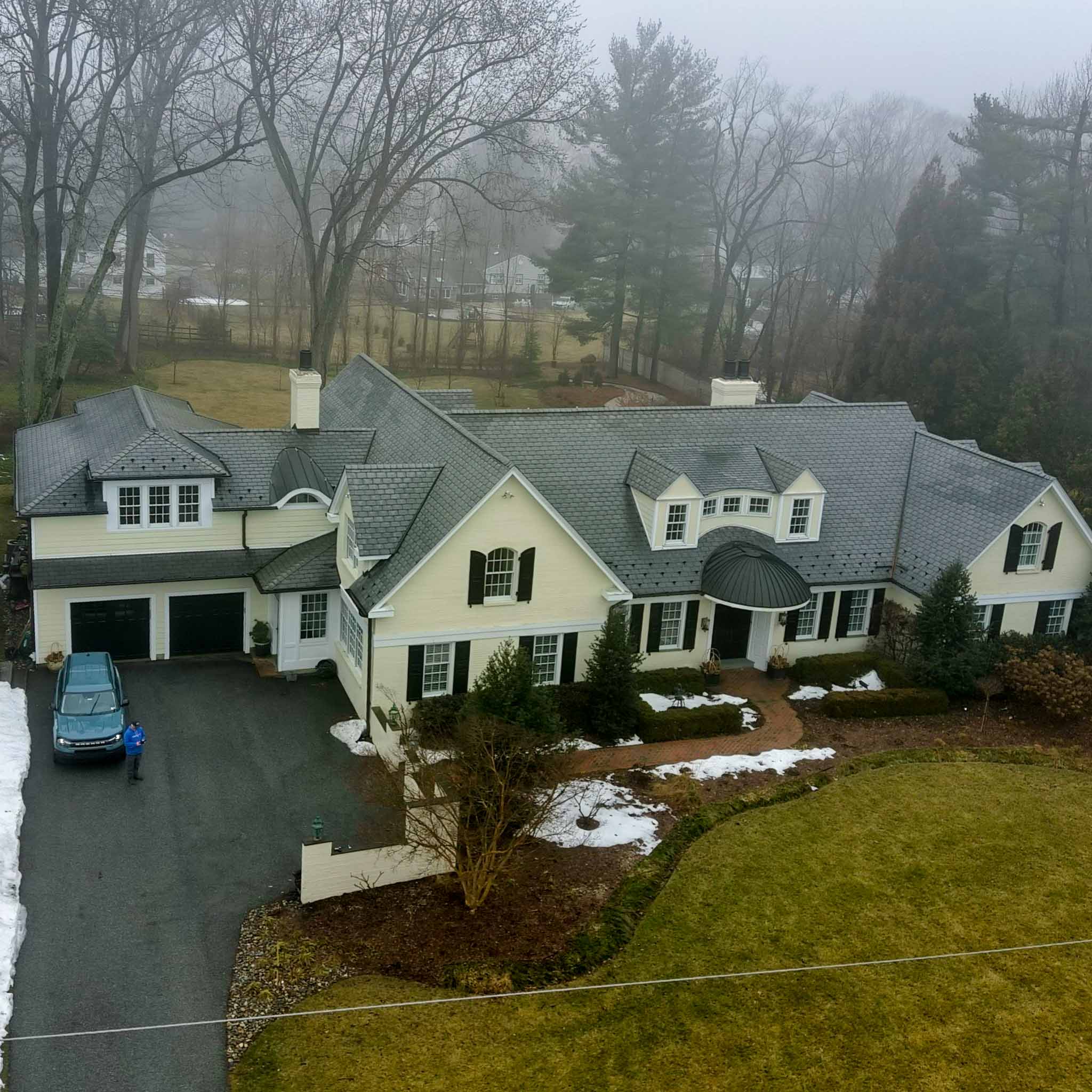 Berwyn Home Inspection — Main Line Estate Large pale-yellow Main Line estate with a slate-look roof, domed copper entry portico and attached garage in Berwyn, Chester County PA, inspected by ValueGuard home inspectors
