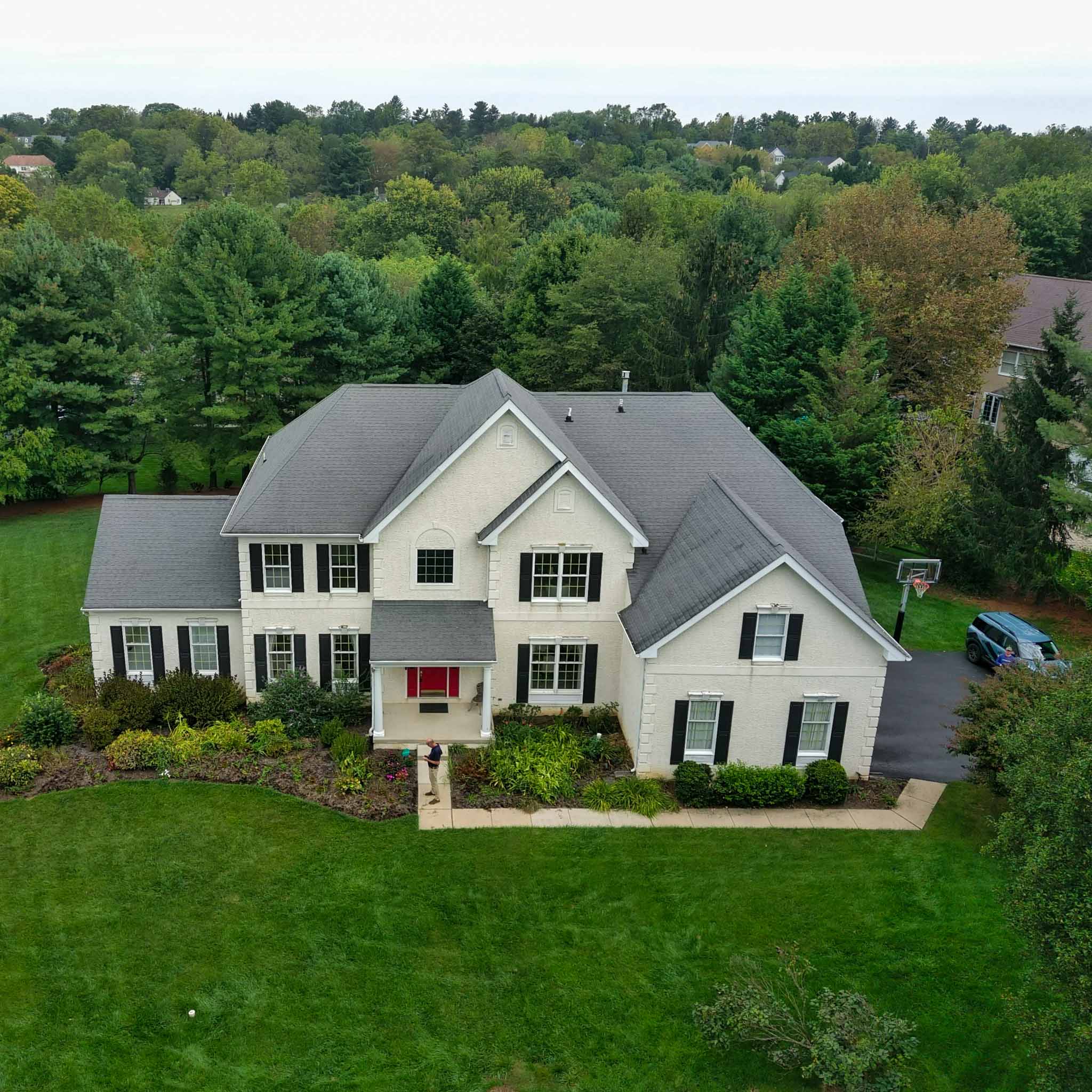 Berwyn Home Inspection — Stucco Colonial Established cream stucco colonial with stone-block quoins and black shutters on a large lot in Berwyn, Chester County PA, inspected by a ValueGuard home inspector