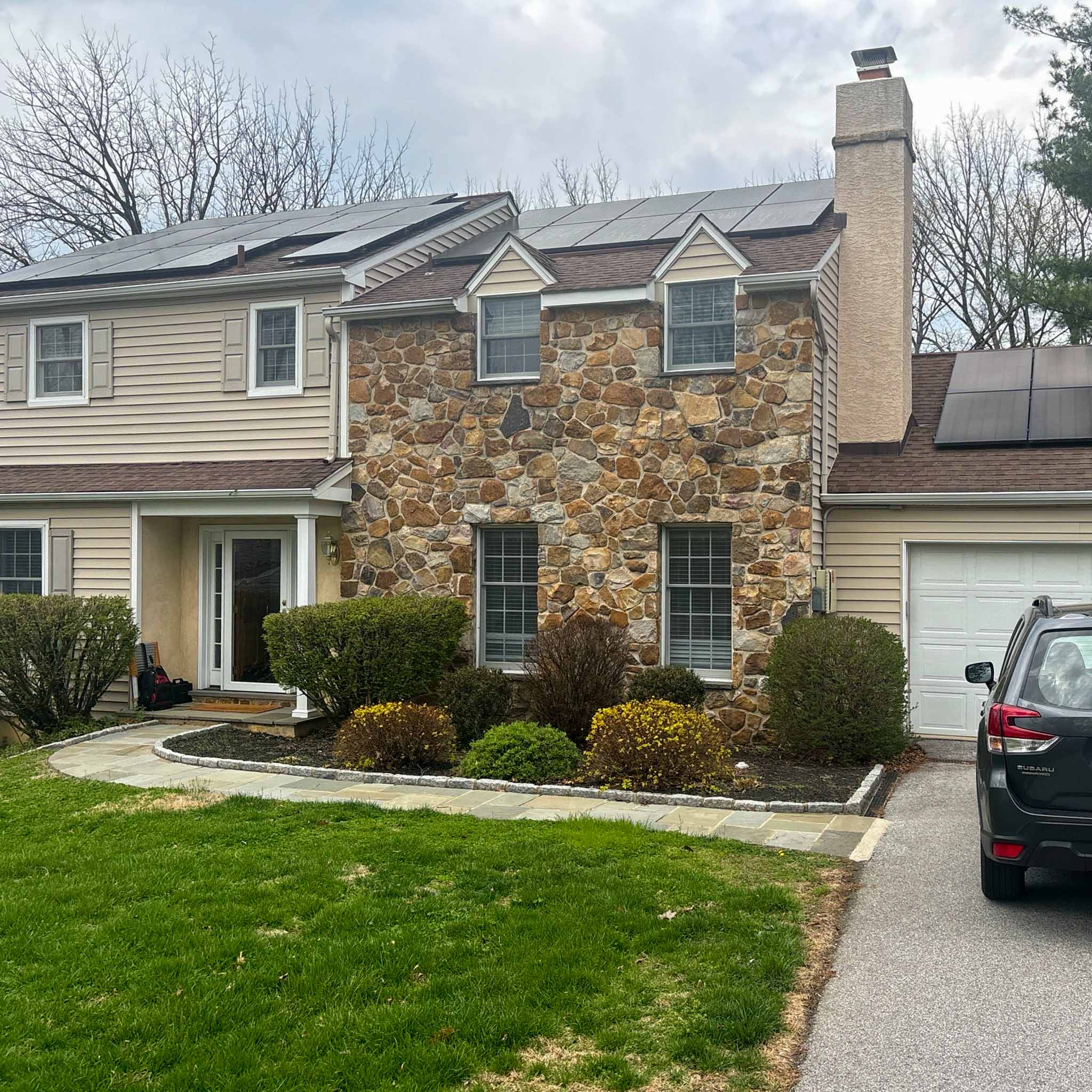 Berwyn Home Inspection — Stone-Front Twin Stone-front twin home with beige siding, a stucco chimney and rooftop solar panels in Berwyn, Chester County PA, inspected by a ValueGuard home inspector