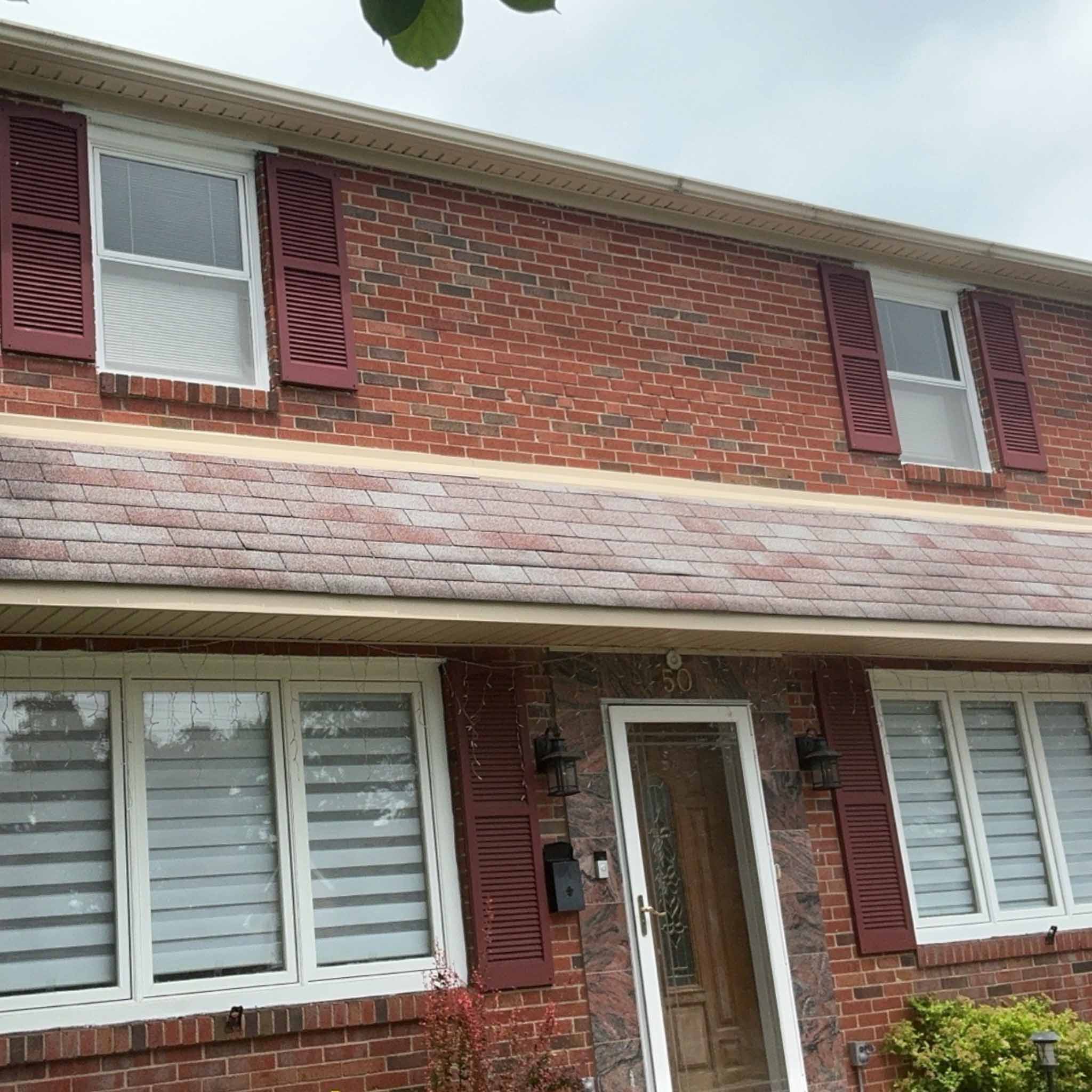 Classic 1960s red-brick Broomall colonial with maroon shutters and an aging porch-roof shingle field inspected by a ValueGuard home inspector