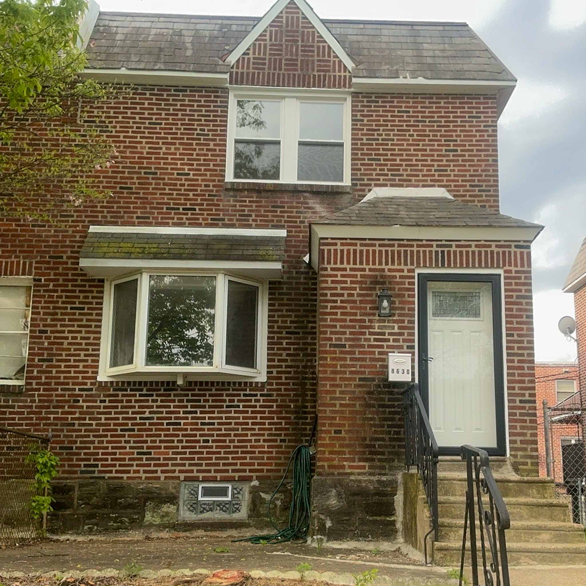 ValueGuard home inspection — end-of-row brick twin with slate-roofed entry and bay window in Cedarbrook Philadelphia