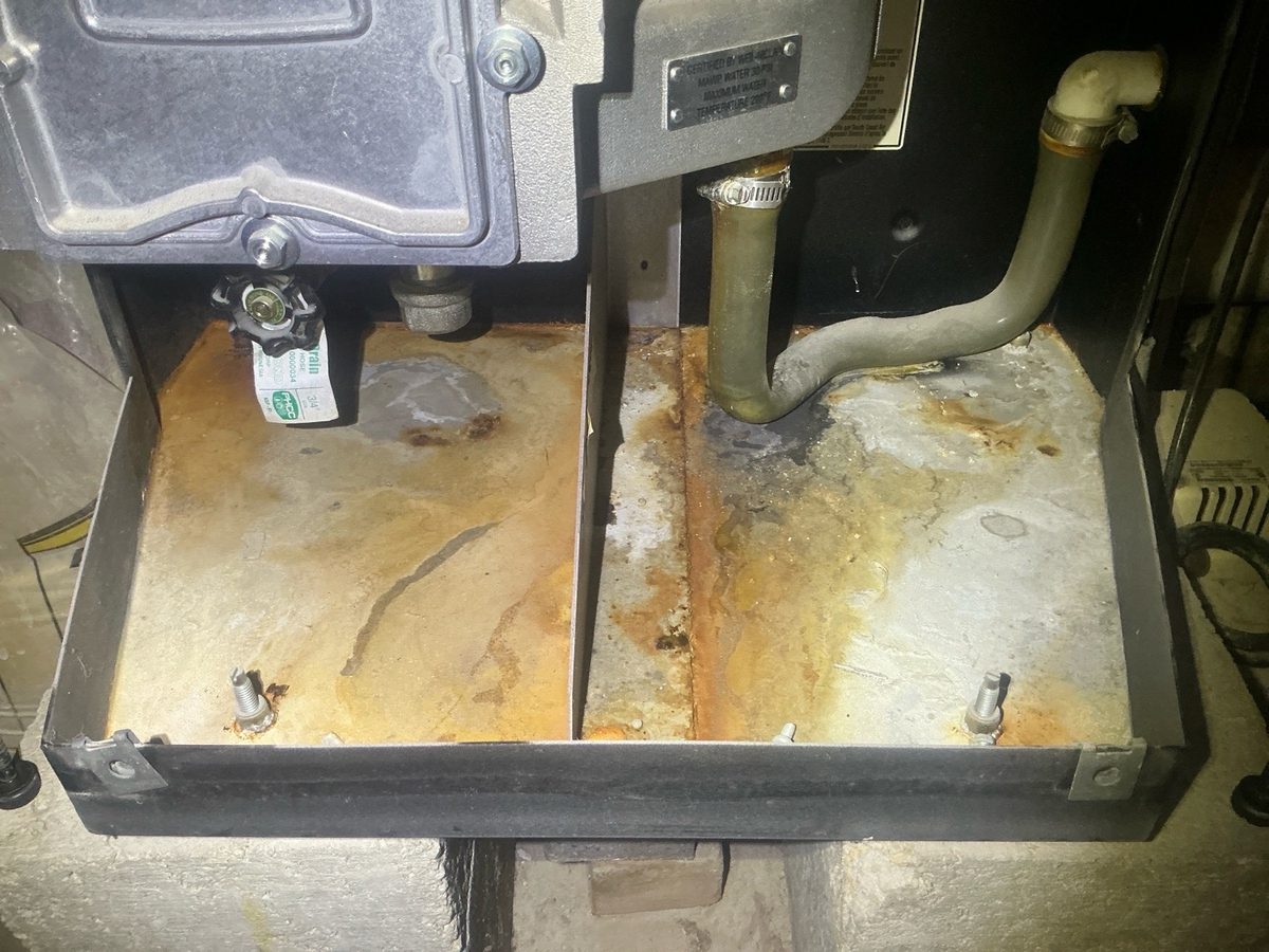 Rust and corrosion in the base of a boiler cabinet found during a home inspection