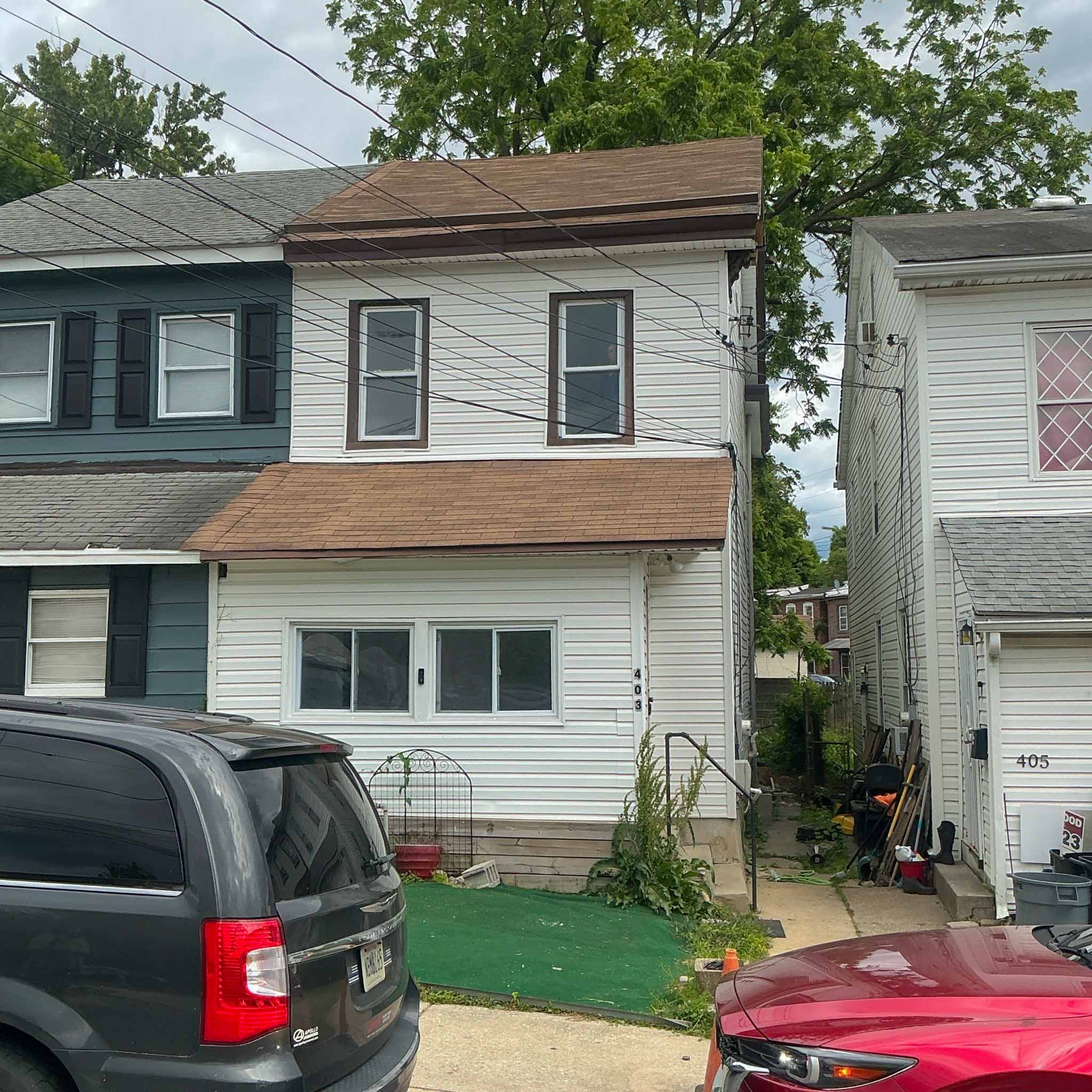 Frame Darby twin re-clad in white vinyl siding with brown shingled pent roofs inspected by ValueGuard home inspectors
