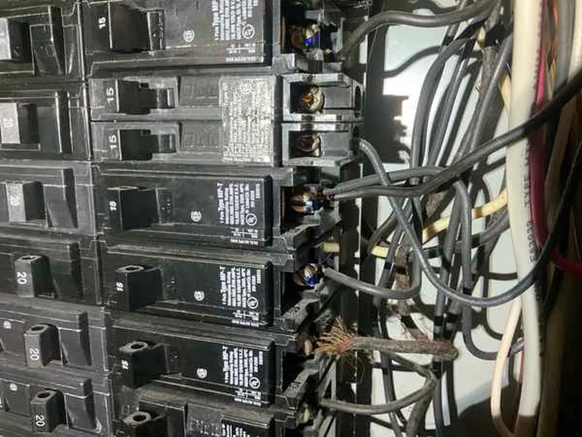 Double tapped breakers with two conductors under a single terminal, documented in a home inspection report
