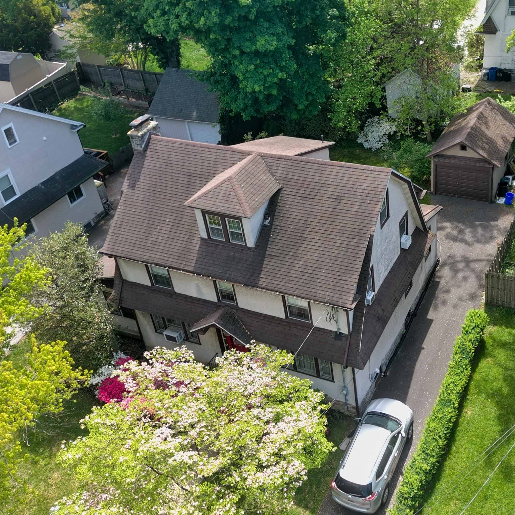 Aerial view of an older stucco-and-shingle Dutch Colonial home in Drexel Hill inspected by ValueGuard home inspectors