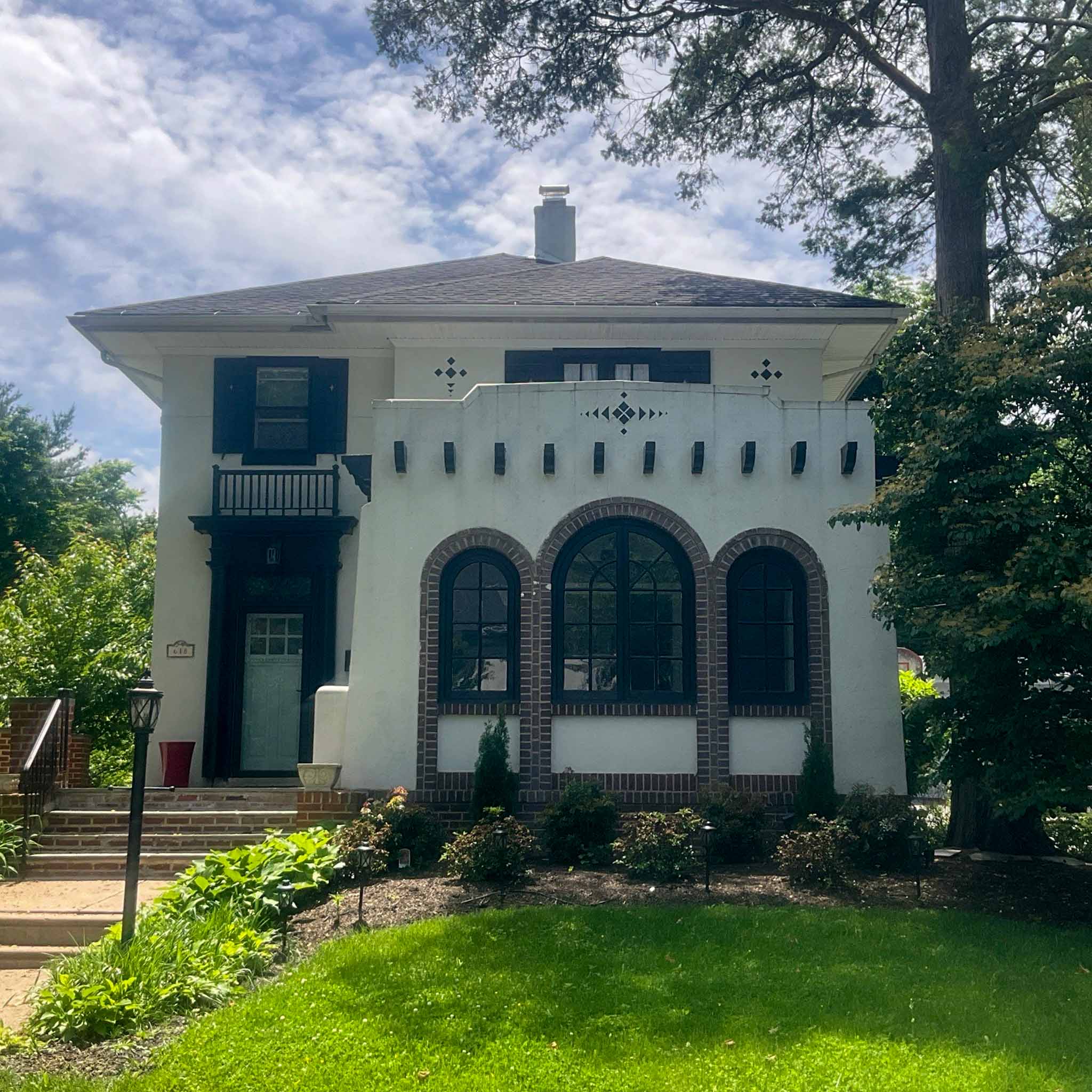 Early-1900s white stucco Mission-style Elkins Park foursquare with arched windows inspected by ValueGuard home inspectors