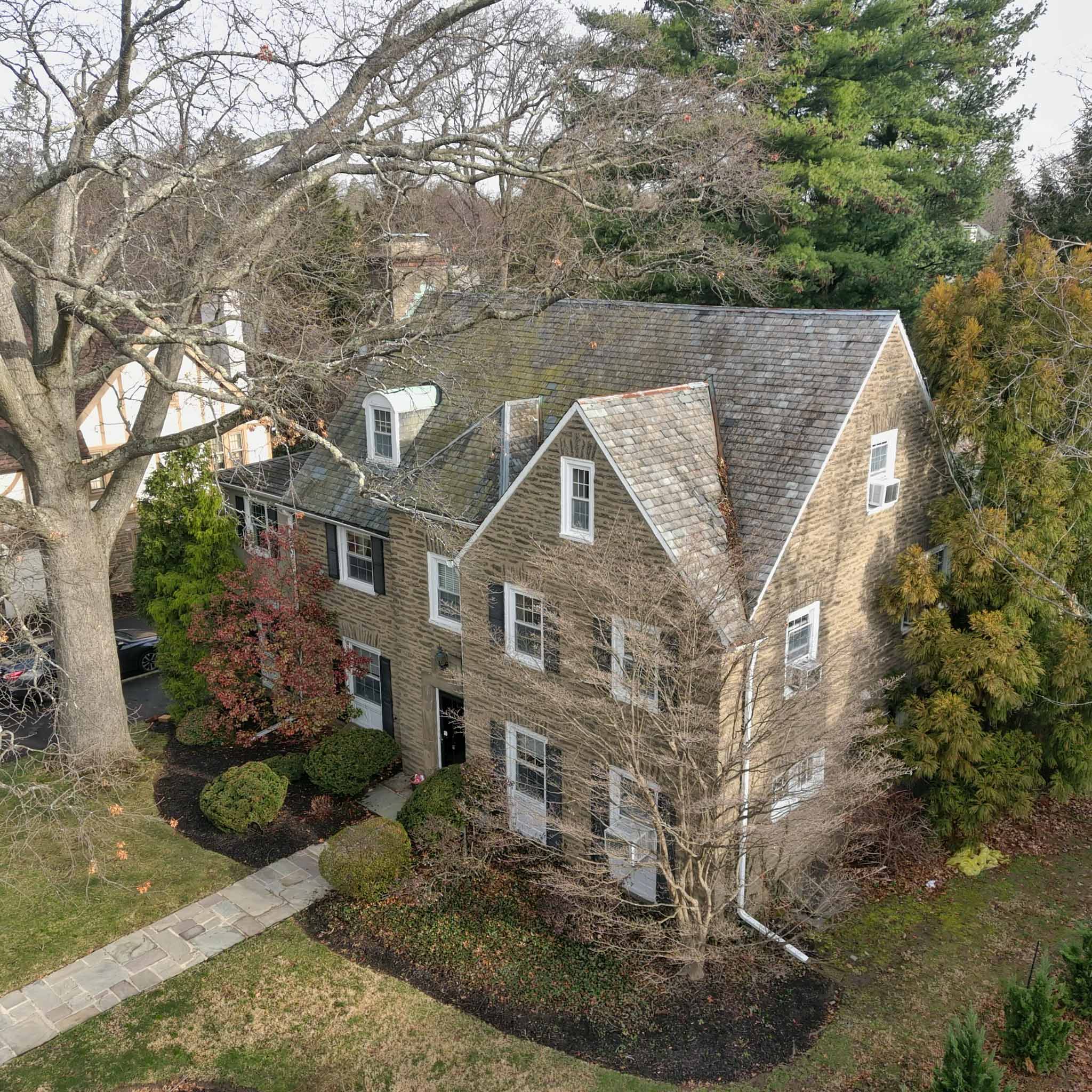 Grand stone Elkins Park colonial under an aged slate roof inspected by a ValueGuard home inspector