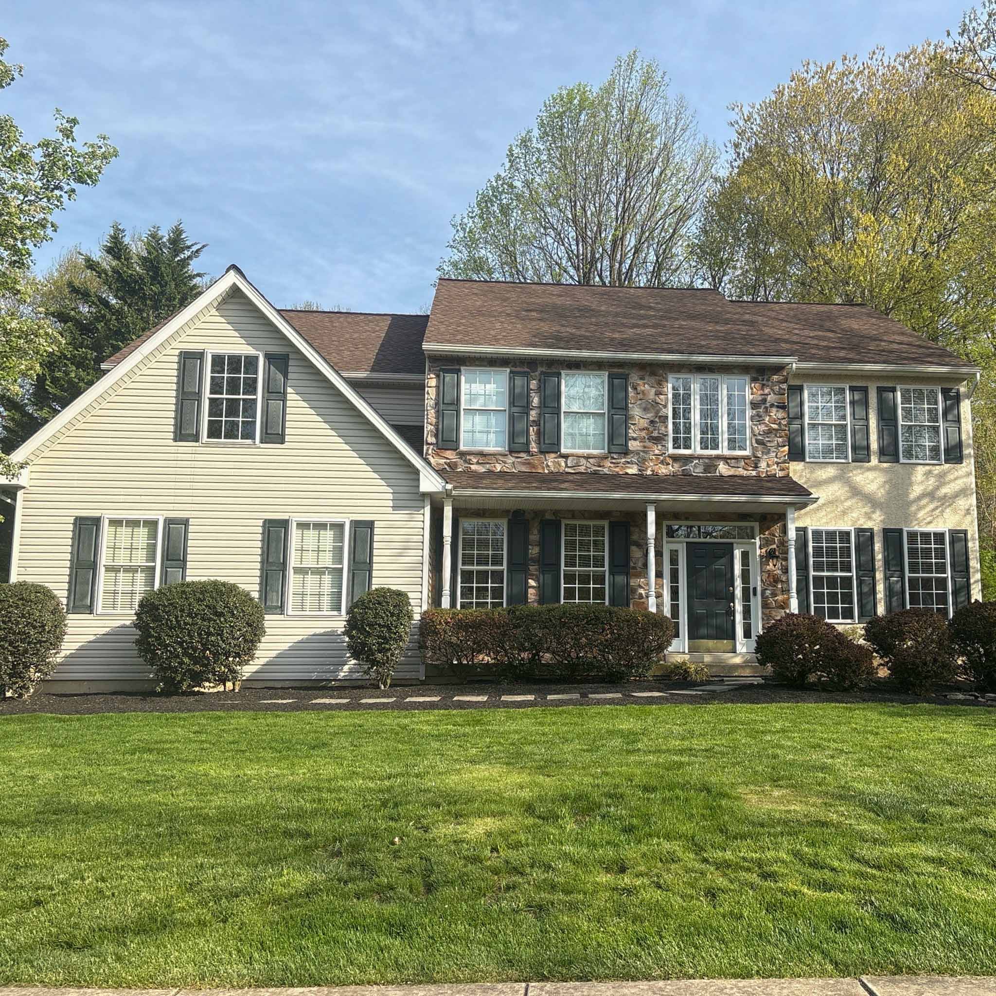 Exton Home Inspection — Established Colonial Established stone-front colonial with siding wings and dark shutters on a large lot in Exton, Chester County PA, inspected by a ValueGuard home inspector