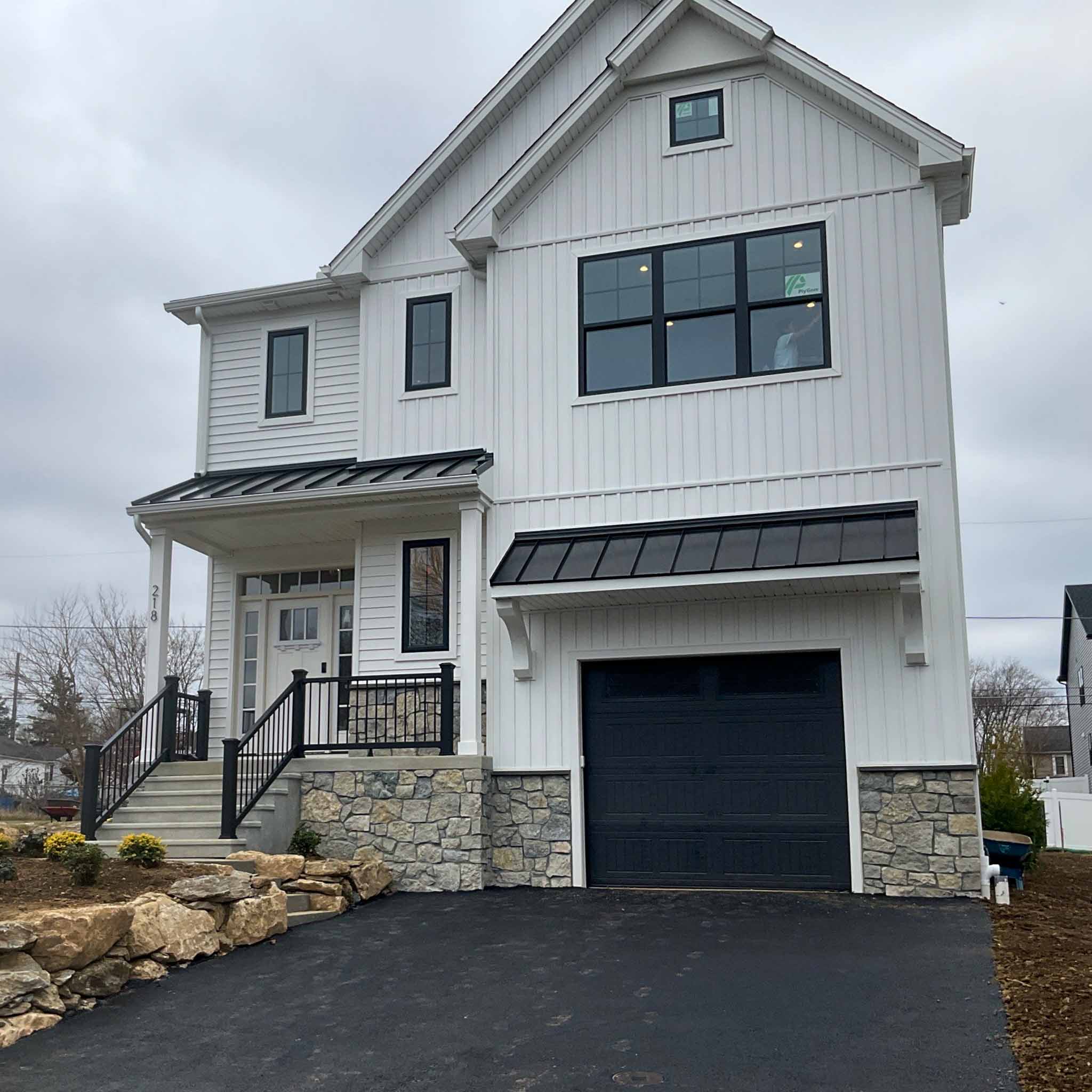 Exton Home Inspection — New Construction Brand-new modern farmhouse with board-and-batten siding, a stone base and black metal awnings in Exton, Chester County PA, inspected by a ValueGuard home inspector
