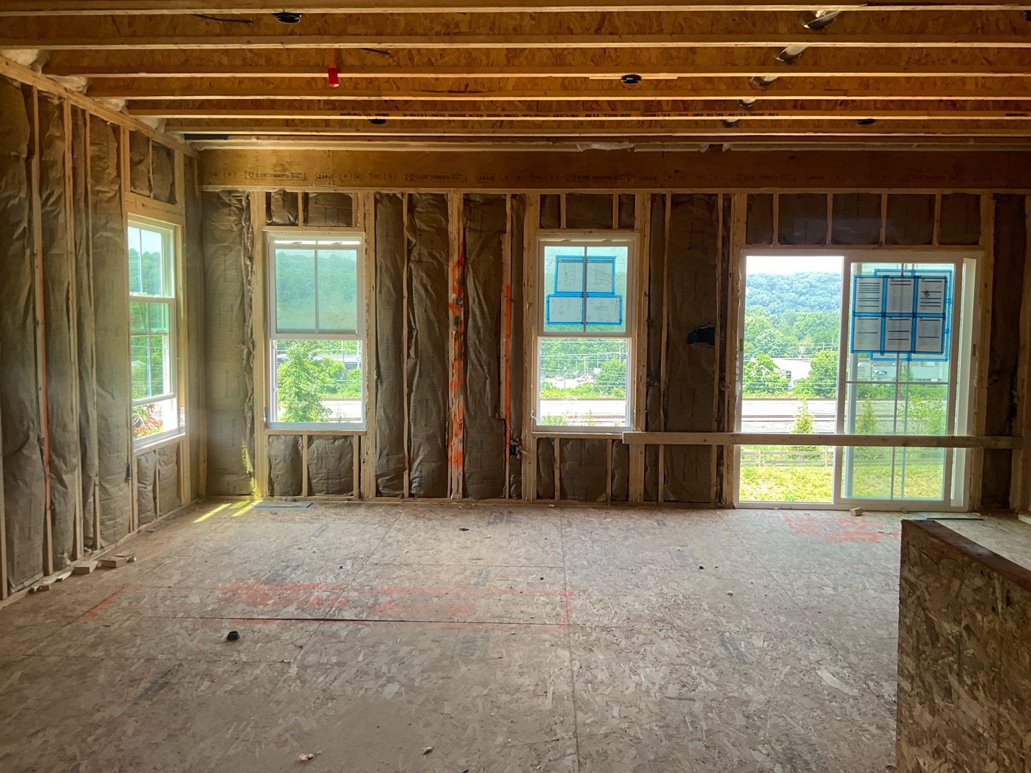 Exposed wall studs, ceiling joists and set windows inside a new-construction home at the pre-drywall stage, ready for a ValueGuard inspection