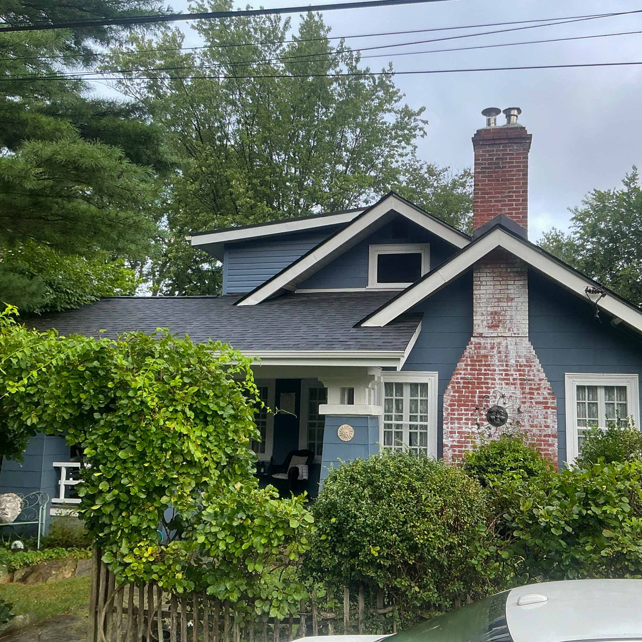 Blue 1920s Glenside craftsman bungalow with deep eaves, a tapered-column porch and a brick chimney inspected by ValueGuard home inspectors