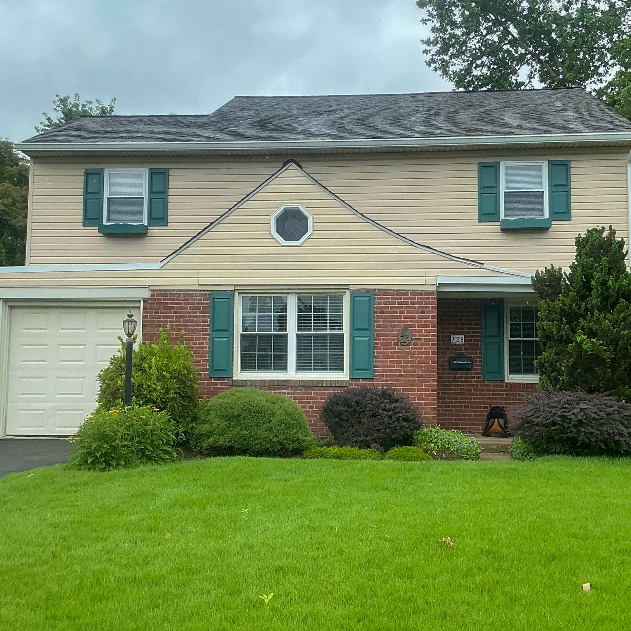 Brick-and-vinyl two-story Glenside colonial with green shutters and an octagonal attic window inspected by a ValueGuard home inspector