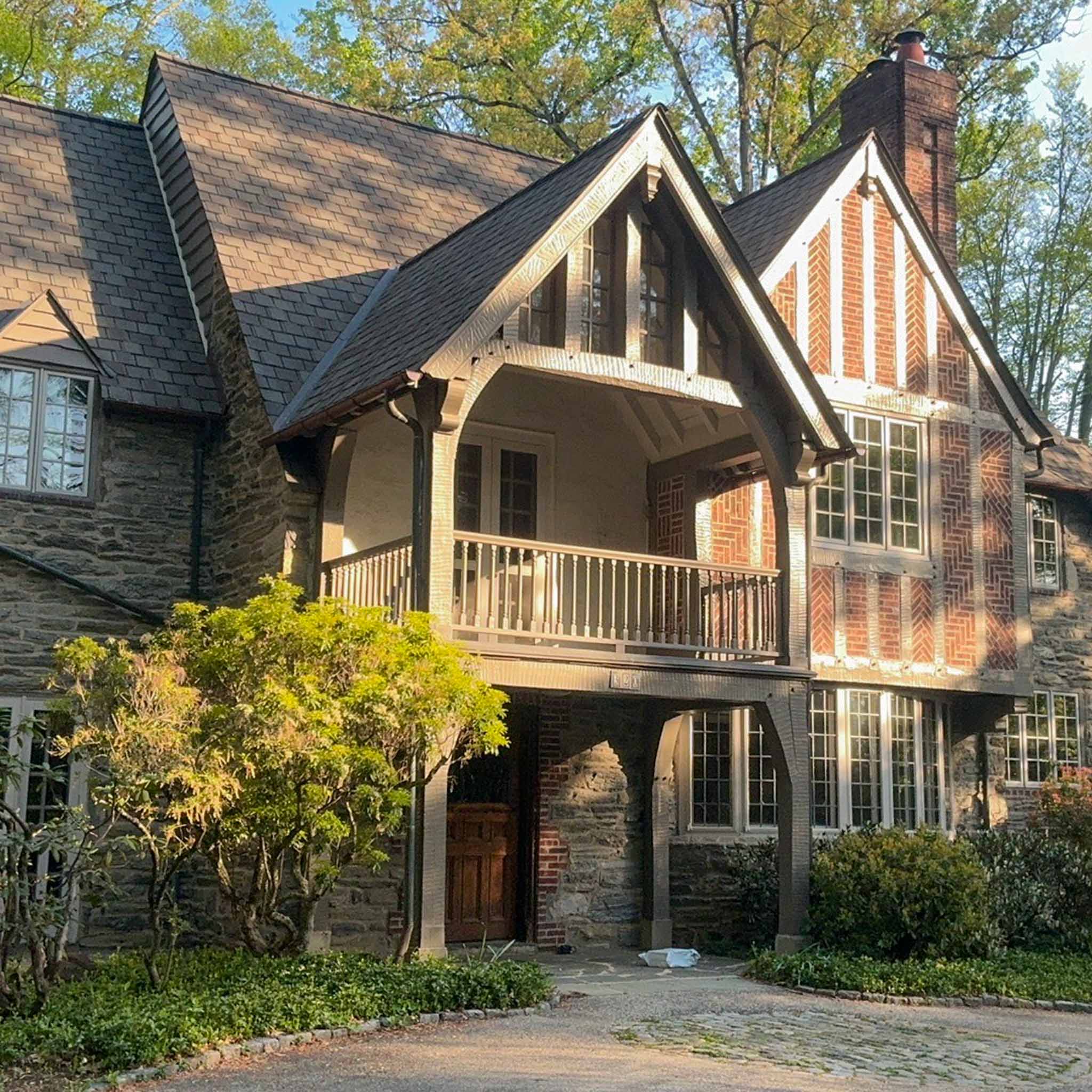 Grand historic stone-and-Tudor estate with slate roof, herringbone-brick gable and arched porte-cochere in Haverford, Montgomery County PA, inspected by a ValueGuard home inspector
