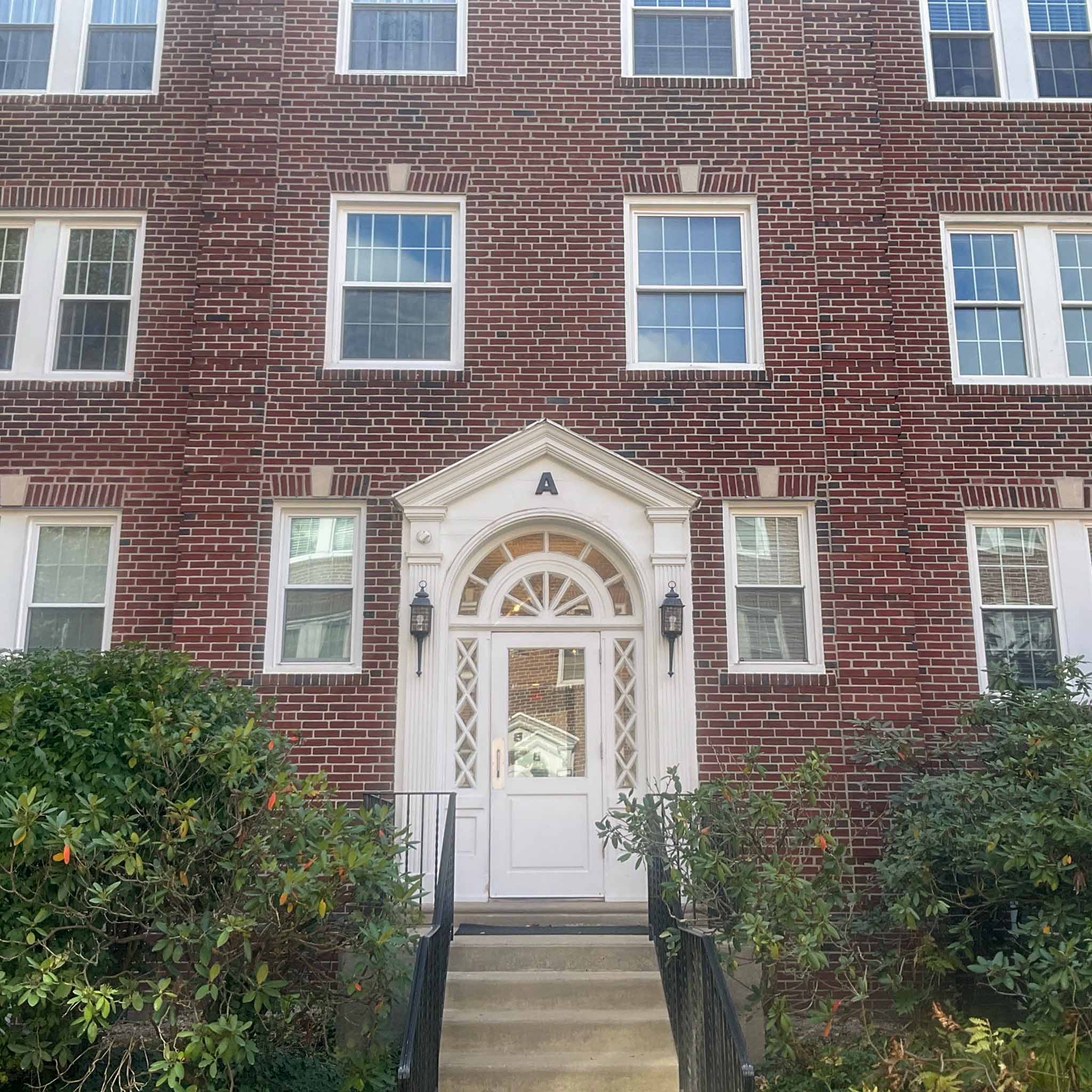 Historic red-brick Colonial-Revival condominium building with a pedimented, fanlight entrance in Haverford, Montgomery County PA, inspected by a ValueGuard home inspector