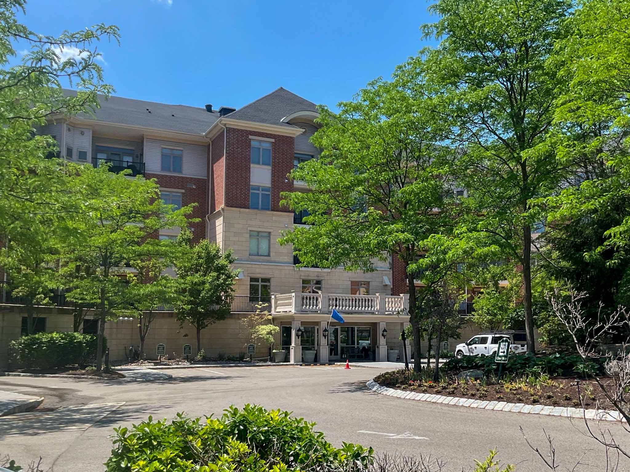 Brick and cast-stone mid-rise condominium building with balconies and a covered entrance in Huntingdon Valley inspected by ValueGuard home inspectors