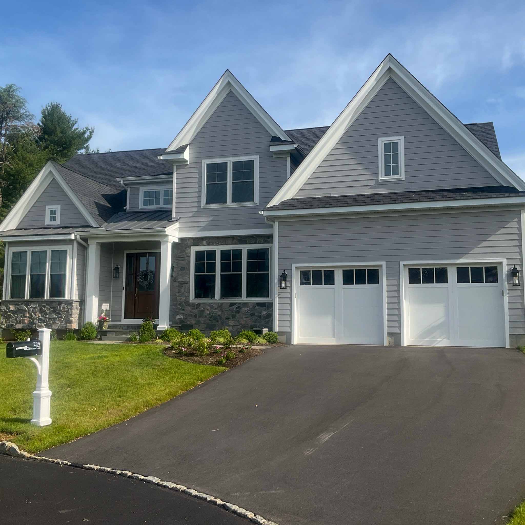 Malvern Home Inspection — New-Construction Home Premium new-construction home with gray lap siding, stone accents and a two-car garage in Malvern, Chester County PA, inspected by ValueGuard home inspectors