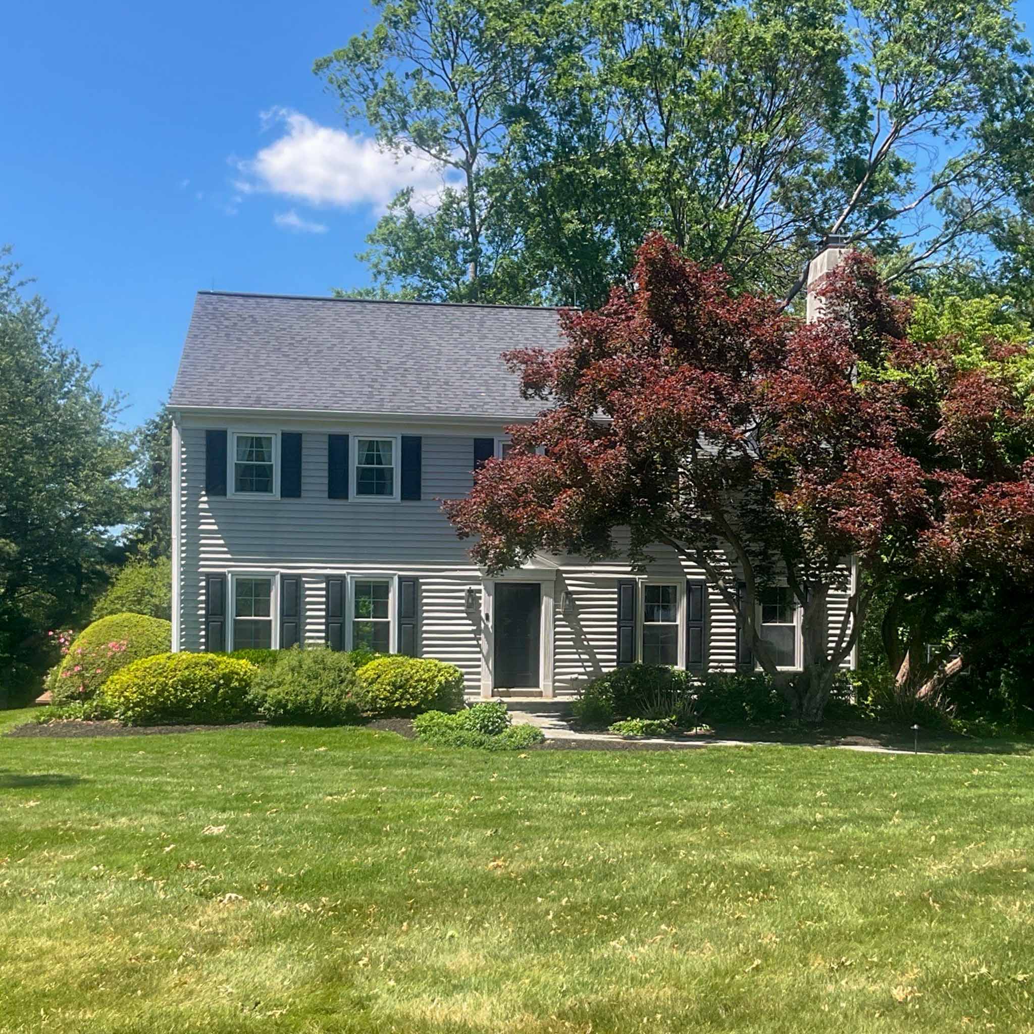 Malvern Home Inspection — Established Colonial Established two-story colonial home with gray siding and black shutters in Malvern, Chester County PA, inspected by a ValueGuard home inspector
