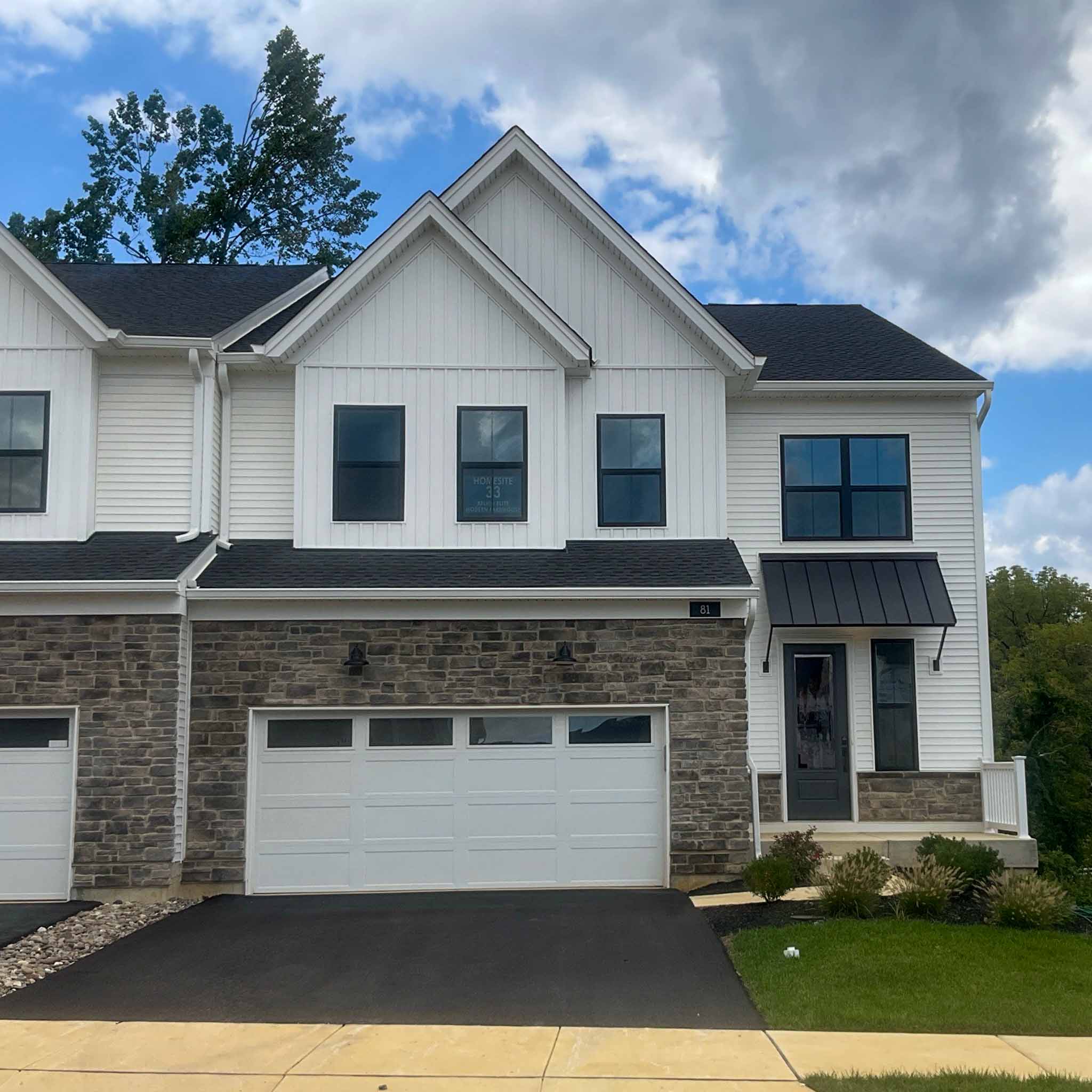 Malvern Home Inspection — New-Construction Townhome New-construction luxury townhome with white modern-farmhouse siding and a stone base in Malvern, Chester County PA, inspected by a ValueGuard home inspector