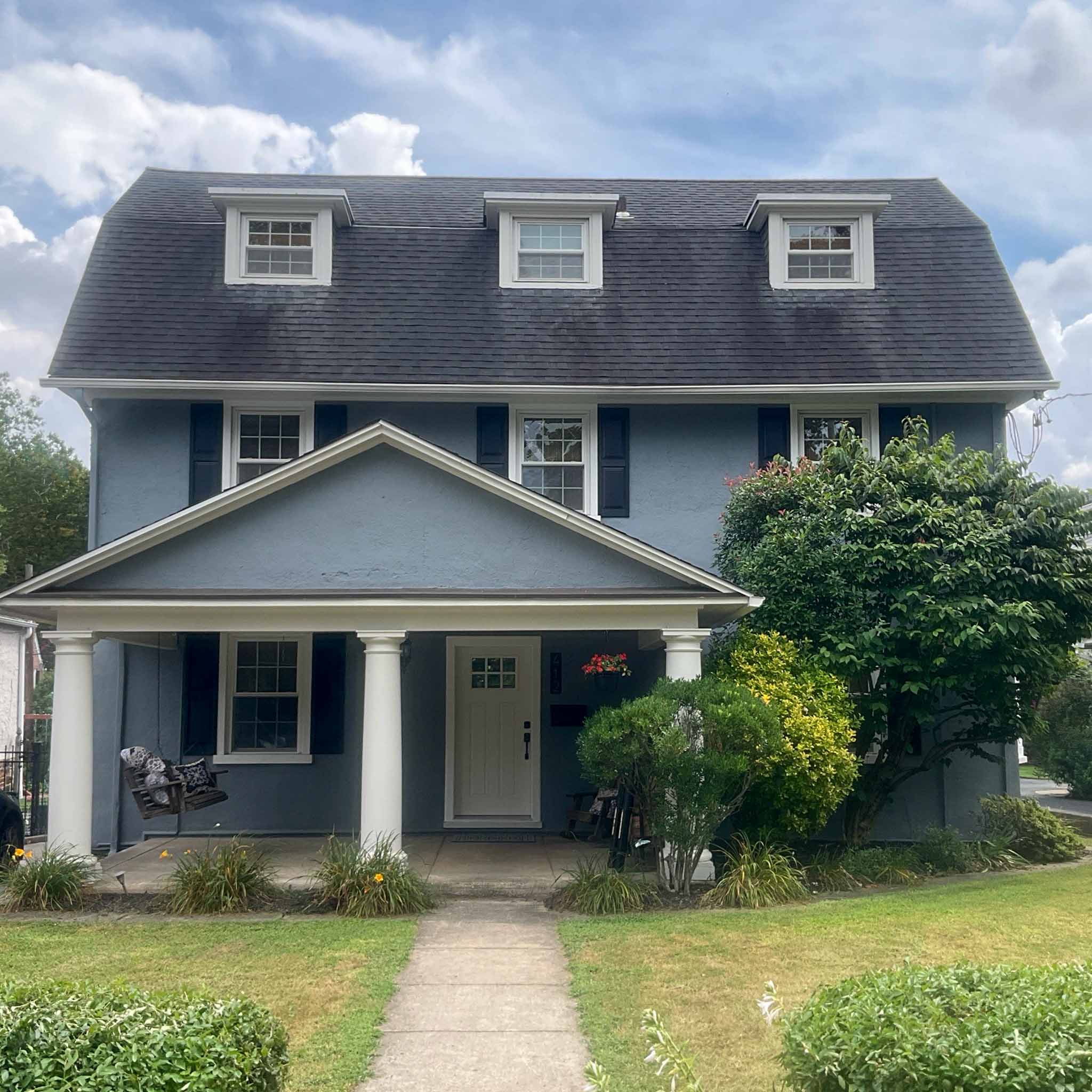 Blue stucco Dutch Colonial with a gambrel roof, dormers and full-width front porch in Narberth inspected by a ValueGuard home inspector