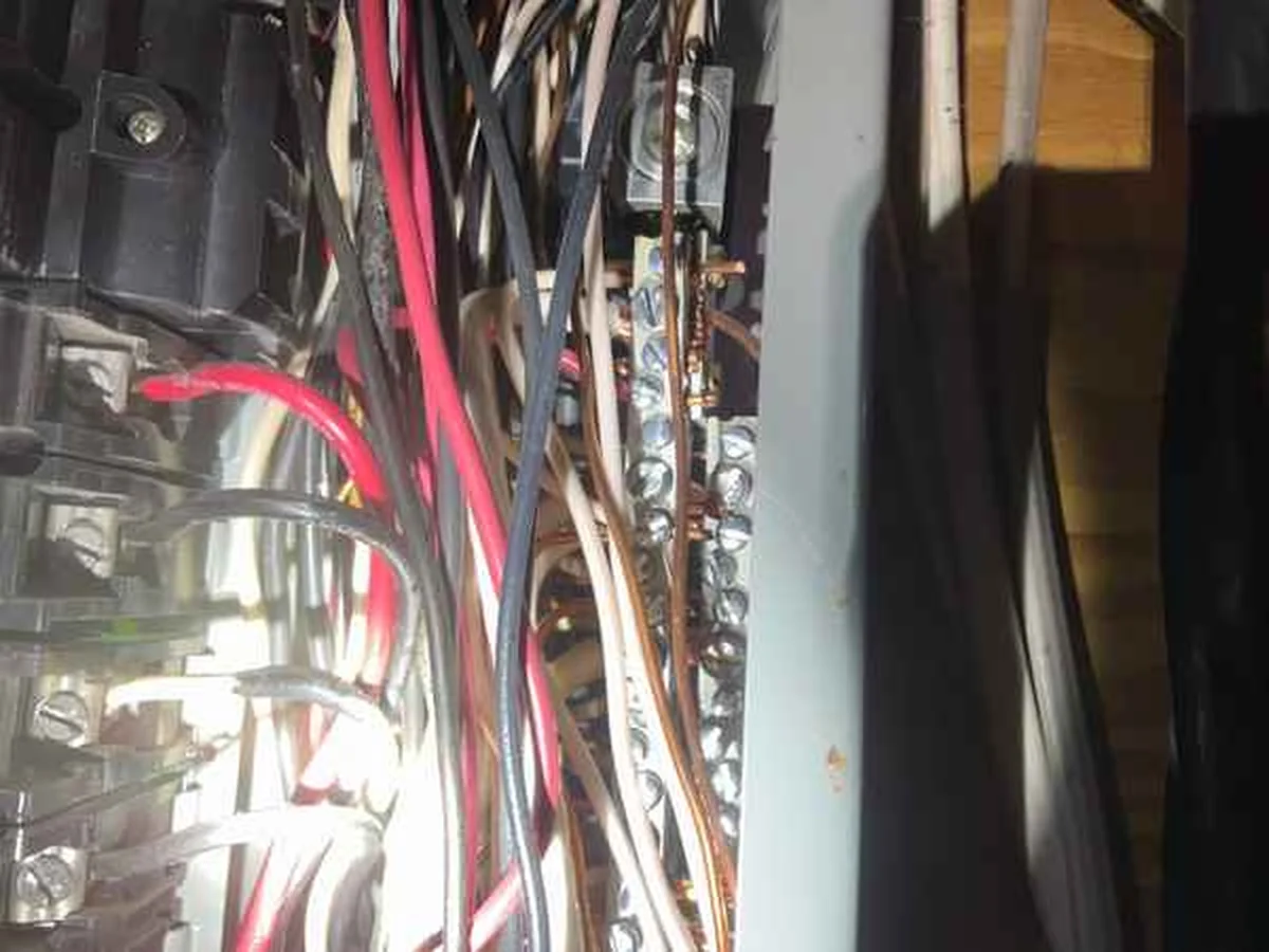 Neutral conductors doubled up at the bus bar inside an electrical service panel during a home inspection