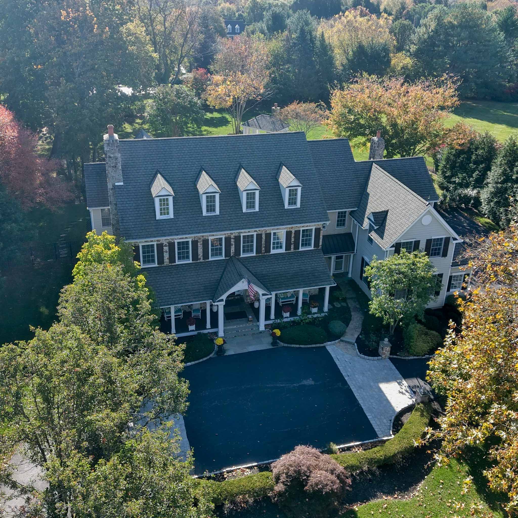 Newtown Square Home Inspection — Custom Stone & Siding Estate Large custom stone-and-siding colonial estate with multiple dormers and chimneys on a wooded Newtown Square lot inspected by ValueGuard home inspectors
