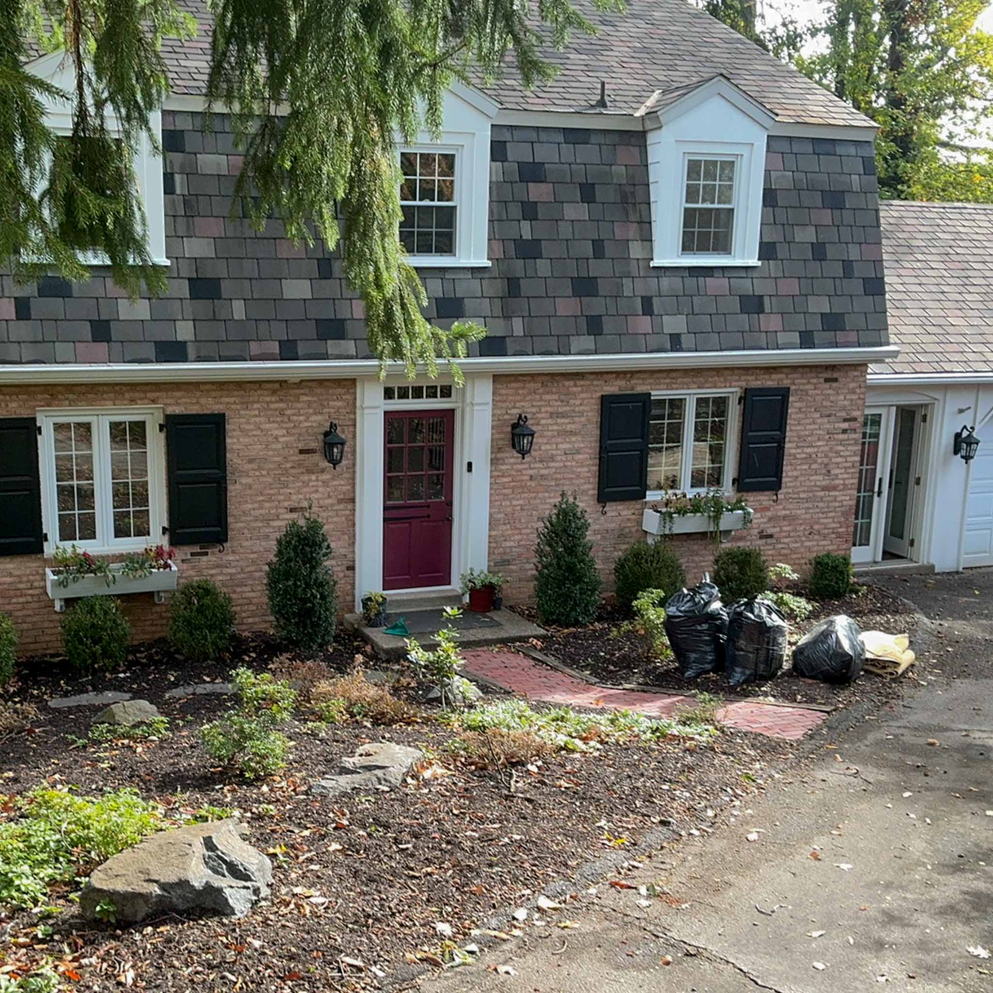 Paoli Home Inspection — Historic Brick Colonial Historic brick colonial with a multicolor slate gambrel roof, dormers and a burgundy door in Paoli, Chester County PA, inspected by a ValueGuard home inspector