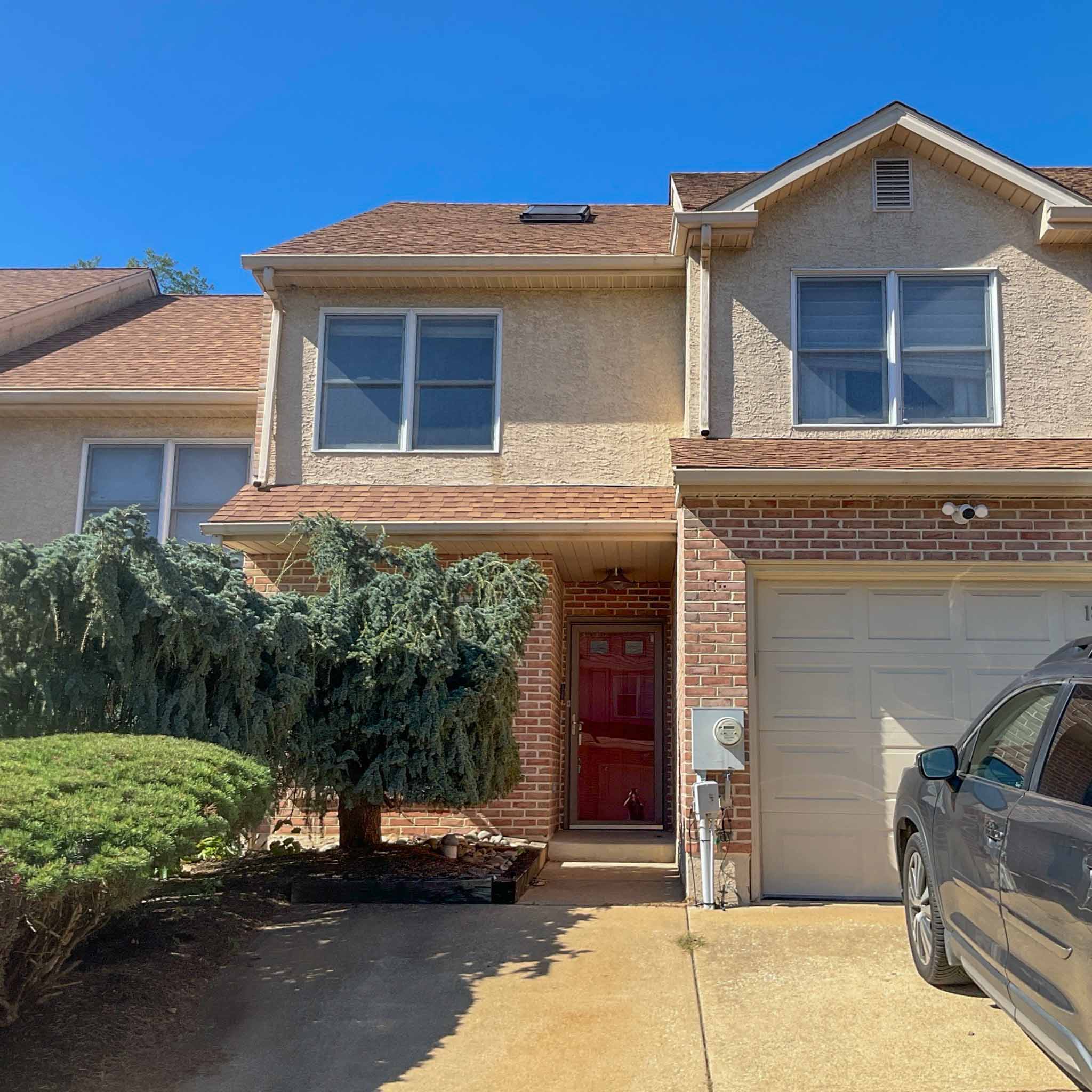 Stucco-and-brick townhome in Plymouth Meeting, PA, an interior unit with an attached garage, inspected by ValueGuard home inspectors
