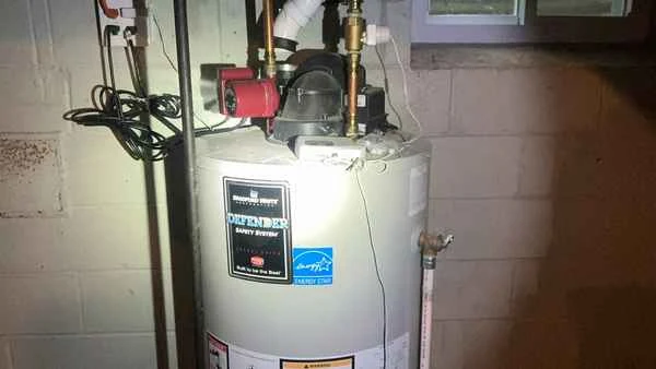 Gas water heater in a Newtown Square basement with vent connector flagged as loose during a post-settlement home inspection