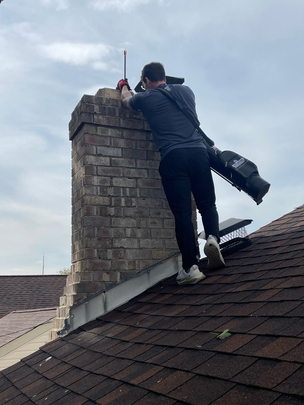 Tyler Gilger on the roof at the chimney crown running a camera down the flue during a Level 2 chimney inspection in Greater Philadelphia
