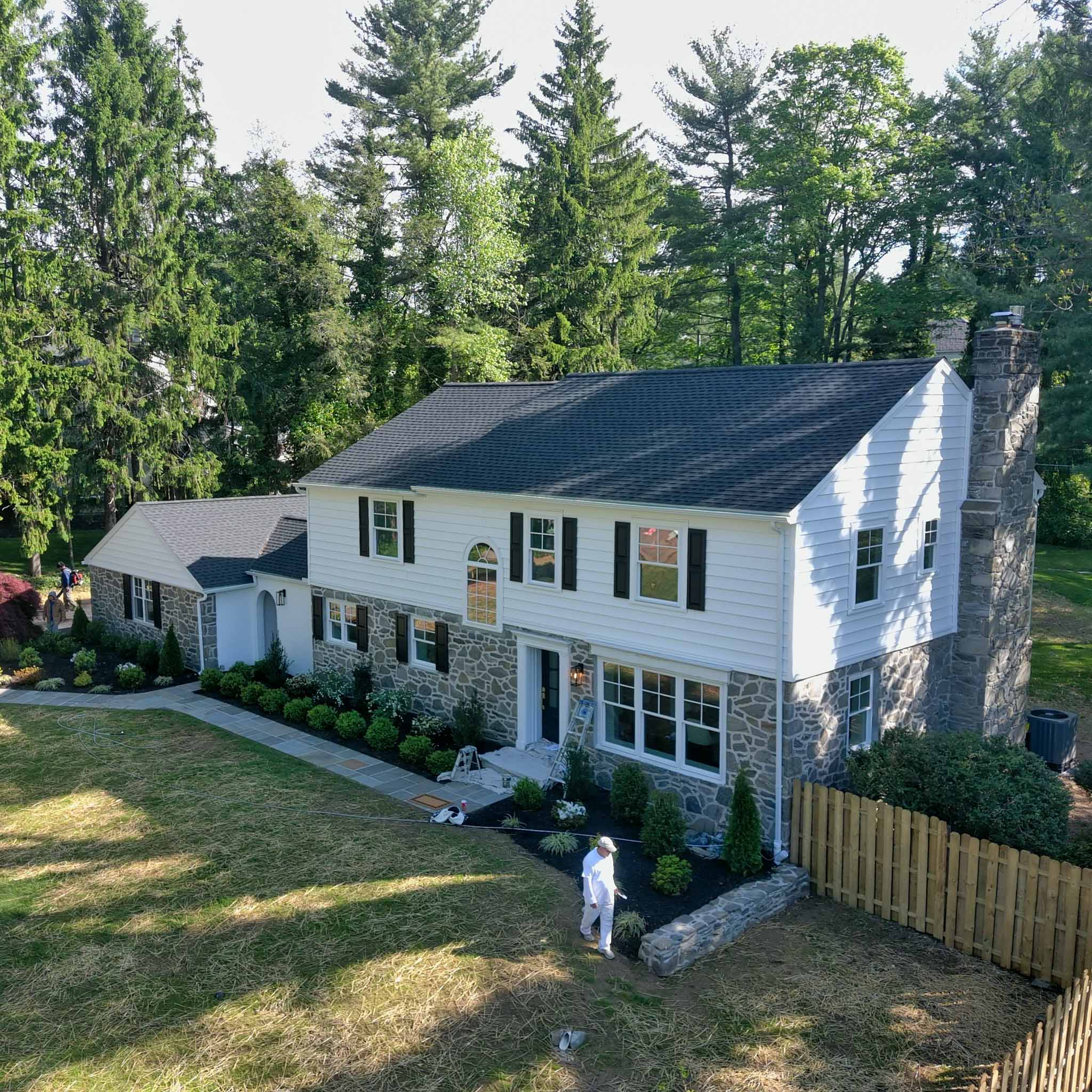 Stone-and-white-clapboard Villanova Colonial mid-renovation with a stone chimney inspected by ValueGuard home inspectors