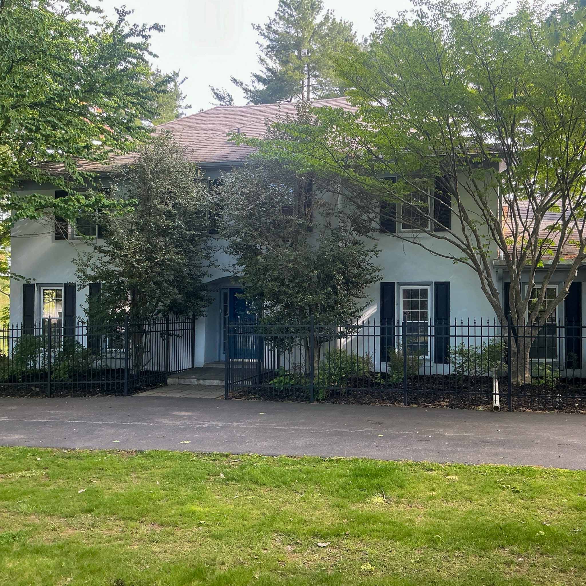 Historic stucco-and-stone Main Line colonial behind a wrought-iron fence in Wayne inspected by a ValueGuard home inspector