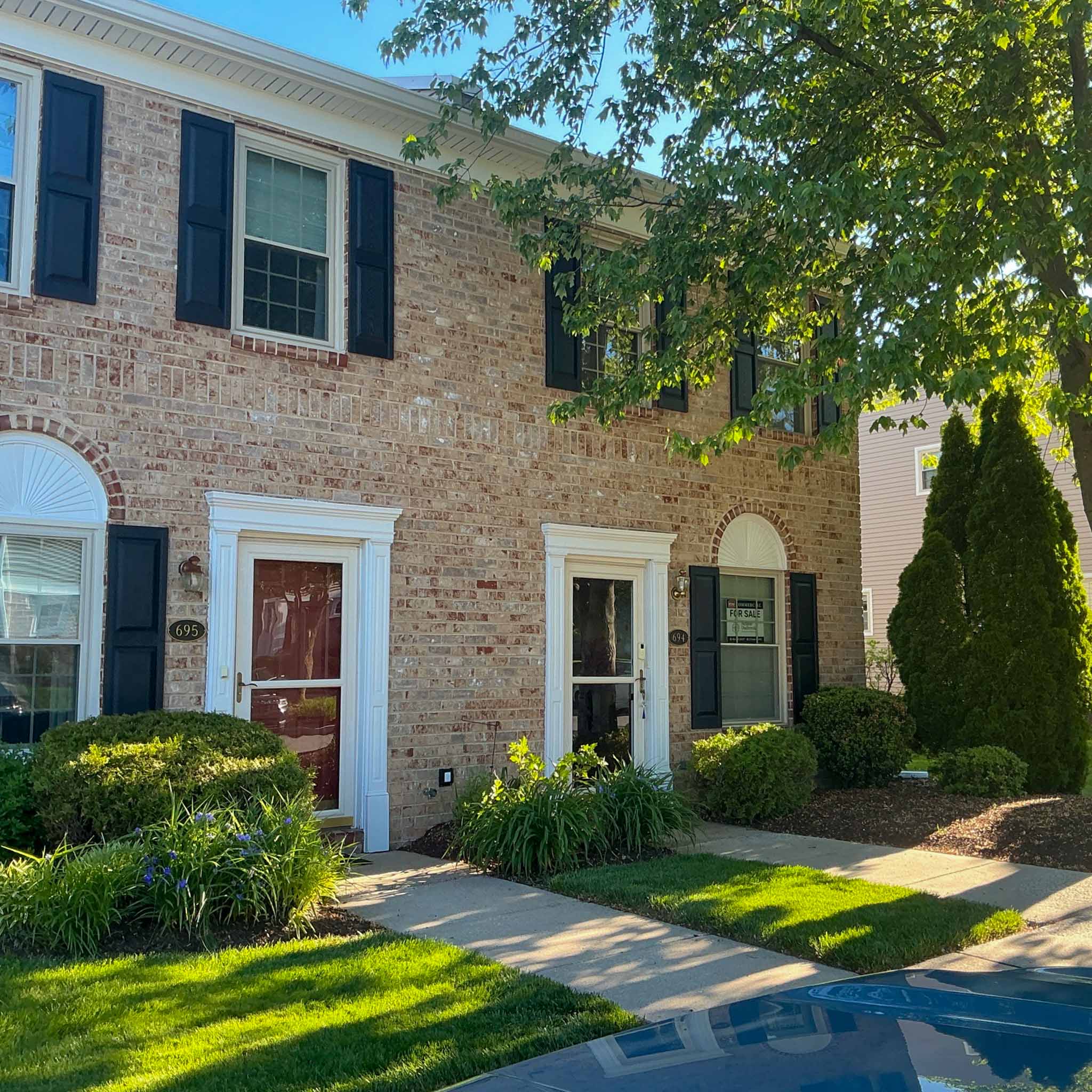West Chester Home Inspection — Borough Brick Rowhome Attached brick Borough rowhomes (units 695 and 694) with black shutters and white-trim entries in West Chester, Chester County PA, inspected by a ValueGuard home inspector