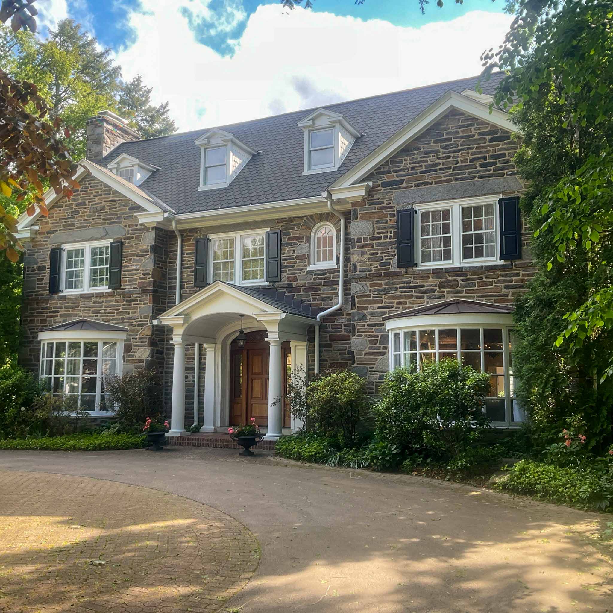Grand early-1900s stone colonial estate with a pedimented portico and copper-roofed bays in Wynnewood inspected by a ValueGuard home inspector