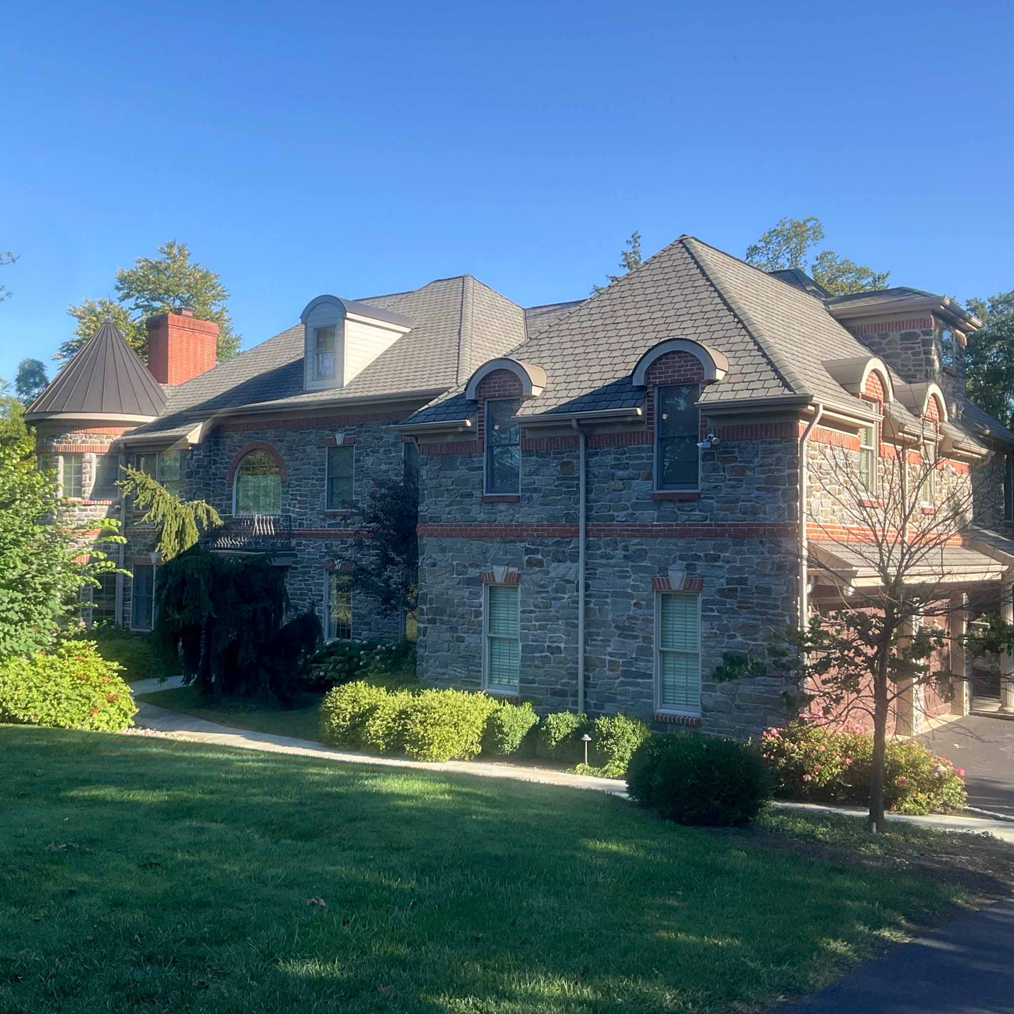 Large newer stone-and-brick manor with arched dormers and a turret in Wynnewood inspected by ValueGuard home inspectors